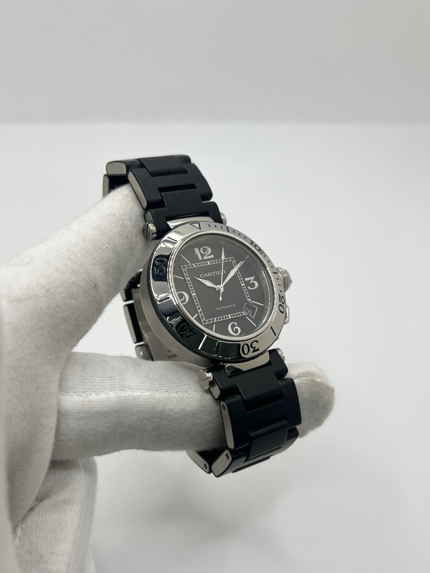 Montre Cartier Pasha Seatimer référence 2790 en acier inoxydable avec boîtier de 40 mm, mouvement automatique calibre 049 basé sur l'ETA 2892-A2 et réserve de marche de 42 heures. Son cadran noir à chiffres arabes est protégé par un verre saphir. Équipée d'un bracelet en acier avec boucle déployante, cette montre est étanche à 10 ATM et dispose d'un guichet date. Vendue avec son coffret et ses papiers d'origine, révisée en interne et en très bon état.
