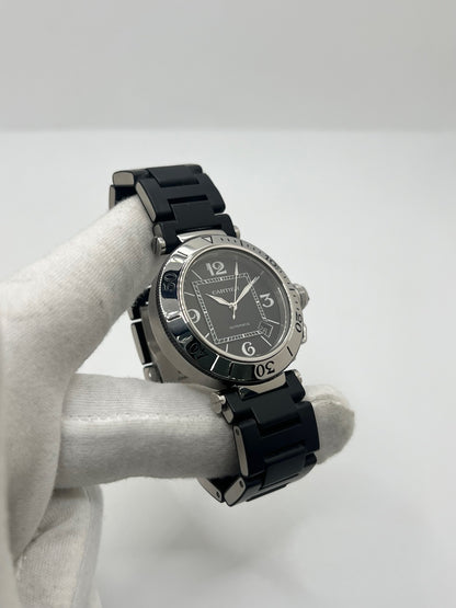 Montre Cartier Pasha Seatimer référence 2790 en acier inoxydable avec boîtier de 40 mm, mouvement automatique calibre 049 basé sur l'ETA 2892-A2 et réserve de marche de 42 heures. Son cadran noir à chiffres arabes est protégé par un verre saphir. Équipée d'un bracelet en acier avec boucle déployante, cette montre est étanche à 10 ATM et dispose d'un guichet date. Vendue avec son coffret et ses papiers d'origine, révisée en interne et en très bon état.