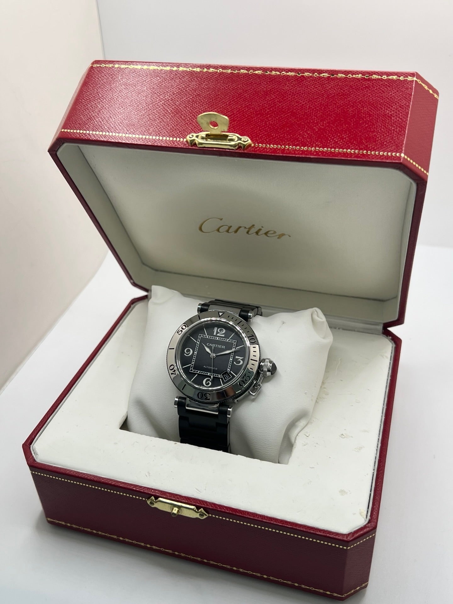 Montre Cartier Pasha Seatimer référence 2790 en acier inoxydable avec boîtier de 40 mm, mouvement automatique calibre 049 basé sur l'ETA 2892-A2 et réserve de marche de 42 heures. Son cadran noir à chiffres arabes est protégé par un verre saphir. Équipée d'un bracelet en acier avec boucle déployante, cette montre est étanche à 10 ATM et dispose d'un guichet date. Vendue avec son coffret et ses papiers d'origine, révisée en interne et en très bon état.