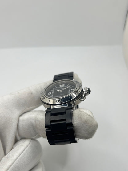 Montre Cartier Pasha Seatimer référence 2790 en acier inoxydable avec boîtier de 40 mm, mouvement automatique calibre 049 basé sur l'ETA 2892-A2 et réserve de marche de 42 heures. Son cadran noir à chiffres arabes est protégé par un verre saphir. Équipée d'un bracelet en acier avec boucle déployante, cette montre est étanche à 10 ATM et dispose d'un guichet date. Vendue avec son coffret et ses papiers d'origine, révisée en interne et en très bon état.