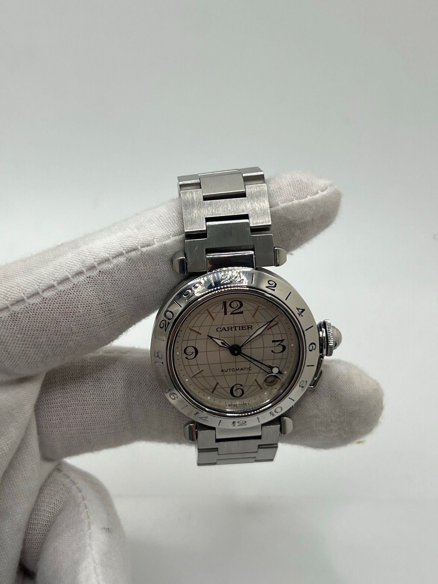 Montre Cartier Pasha C GMT réf. 2377 en acier, dotée d’un mouvement automatique calibre 048. Son boîtier de 35 mm abrite un cadran argenté à chiffres arabes, protégé par un verre saphir. Étanche jusqu’à 10 ATM, cette montre élégante et fonctionnelle est équipée d’un bracelet en acier et d’une boucle déployante double plis.