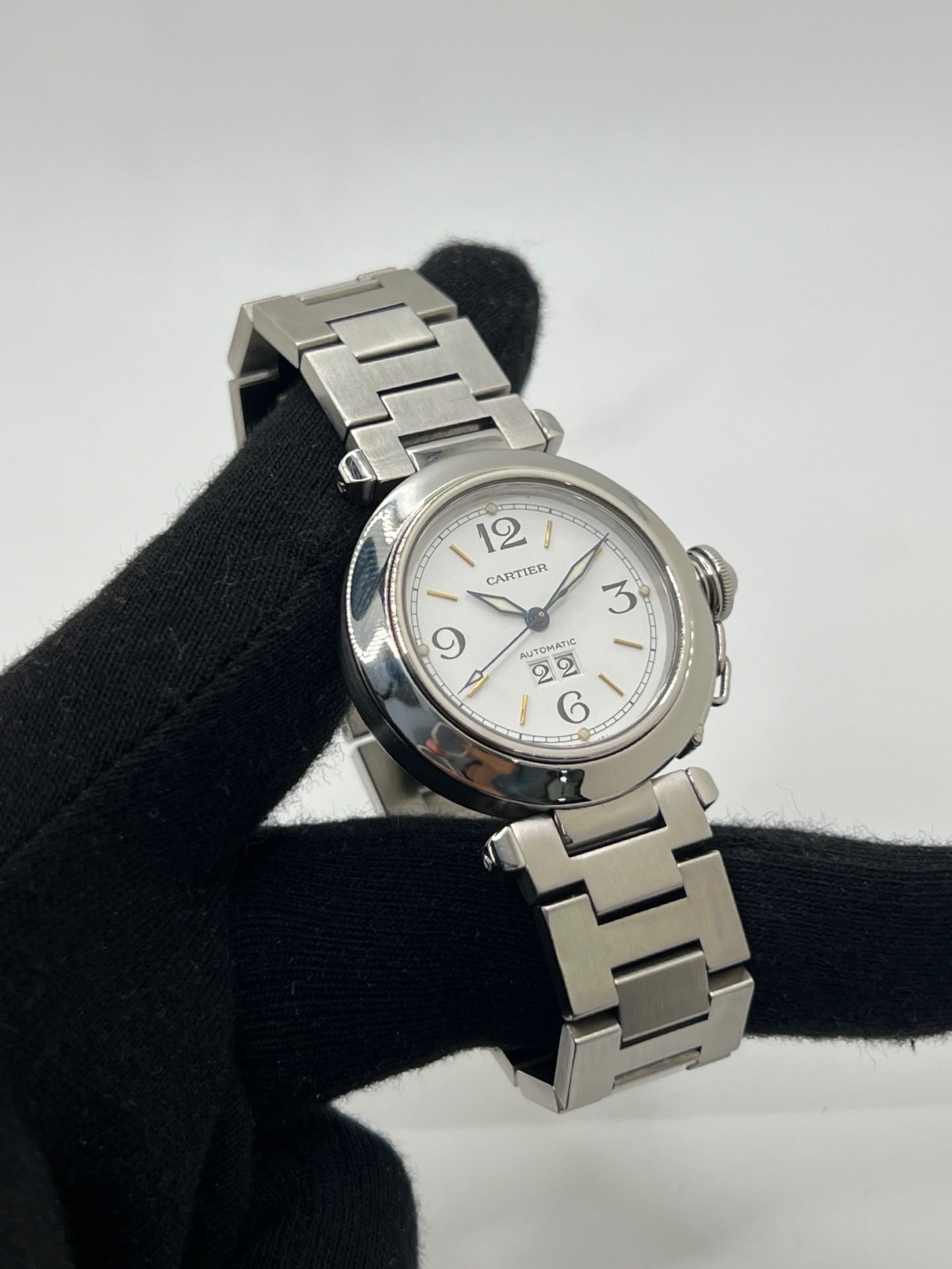 Montre de luxe Cartier Pasha C référence 2475 en acier, équipée d’un mouvement automatique calibre 052. Son boîtier de 35 mm et son cadran blanc à chiffres arabes offrent un style élégant et intemporel. Avec verre saphir, étanchéité 10 ATM et bracelet en acier, cette Pasha C combine performance, précision et raffinement.