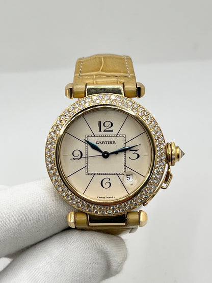 Montre Cartier Pasha 820901 en or jaune, équipée d’un mouvement automatique et d’un boîtier de 38 mm. Son cadran blanc est protégé par un verre saphir et son boîtier offre une étanchéité jusqu’à 10 ATM. Cette montre Cartier Pasha est montée sur un bracelet beige en cuir de crocodile avec boucle déployante en or rose. Dotée d’un affichage de la date, elle associe élégance, caractère et raffinement. Un modèle iconique en très bon état.