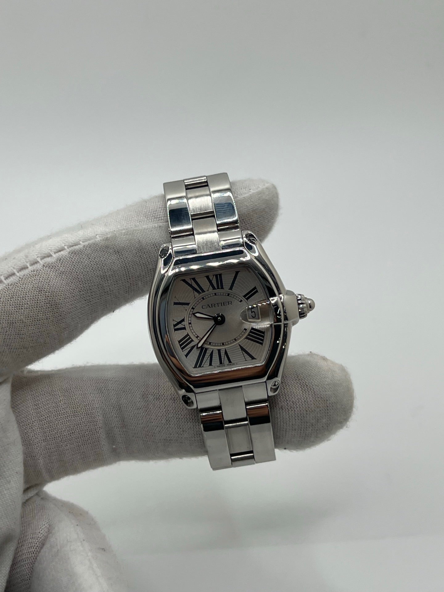 Montre Cartier Roadster 2675 pour femme en acier, équipée d’un mouvement quartz calibre 688. Boîtier 31 x 37 mm avec verre saphir, cadran argent à chiffres romains et bracelet acier à boucle déployante. Modèle étanche à 10 ATM avec fonction date, livré avec coffret d’origine, en très bon état d’occasion.