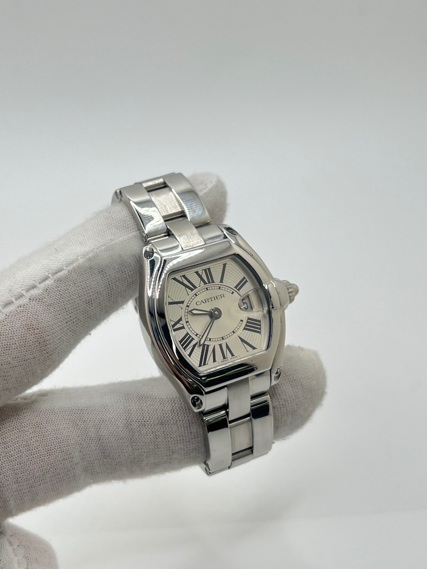 Montre Cartier Roadster 2675 pour femme en acier, équipée d’un mouvement quartz calibre 688. Boîtier 31 x 37 mm avec verre saphir, cadran argent à chiffres romains et bracelet acier à boucle déployante. Modèle étanche à 10 ATM avec fonction date, livré avec coffret d’origine, en très bon état d’occasion.