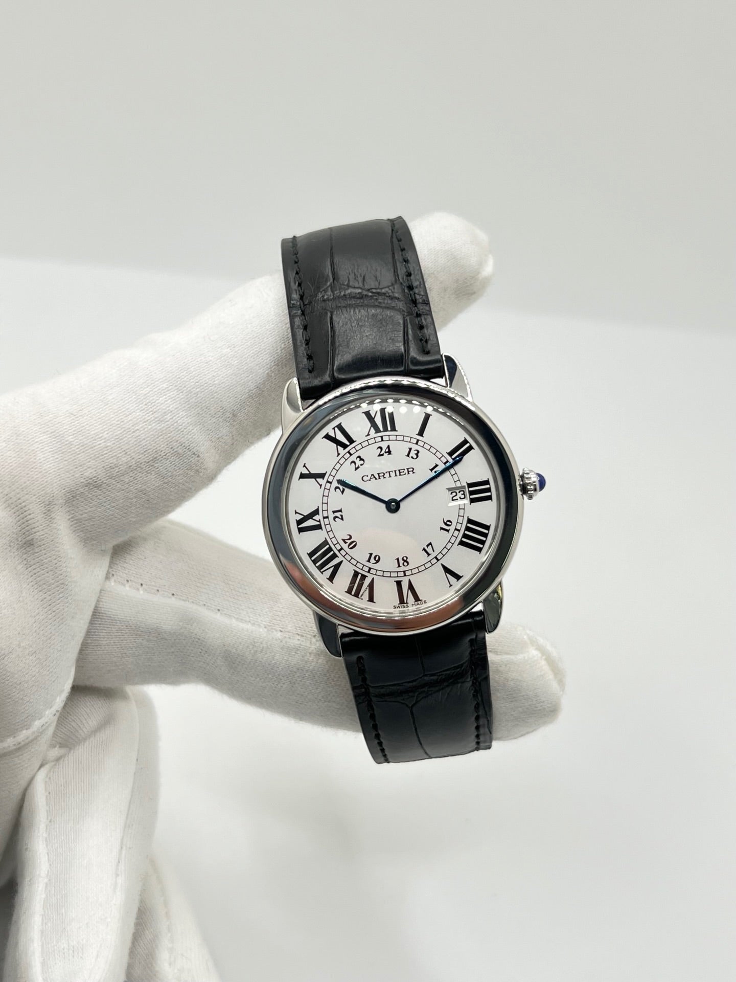 Montre Cartier Ronde Solo en acier avec cadran argent à chiffres romains, mouvement quartz et fonction date. Boîtier rond 36 x 39 mm avec verre saphir et étanchéité 3 ATM. Bracelet en cuir noir avec boucle ardillon en acier. Design classique et élégant, idéal pour homme ou unisexe. Montre d’occasion en très bon état, révisée, avec coffret d’origine.