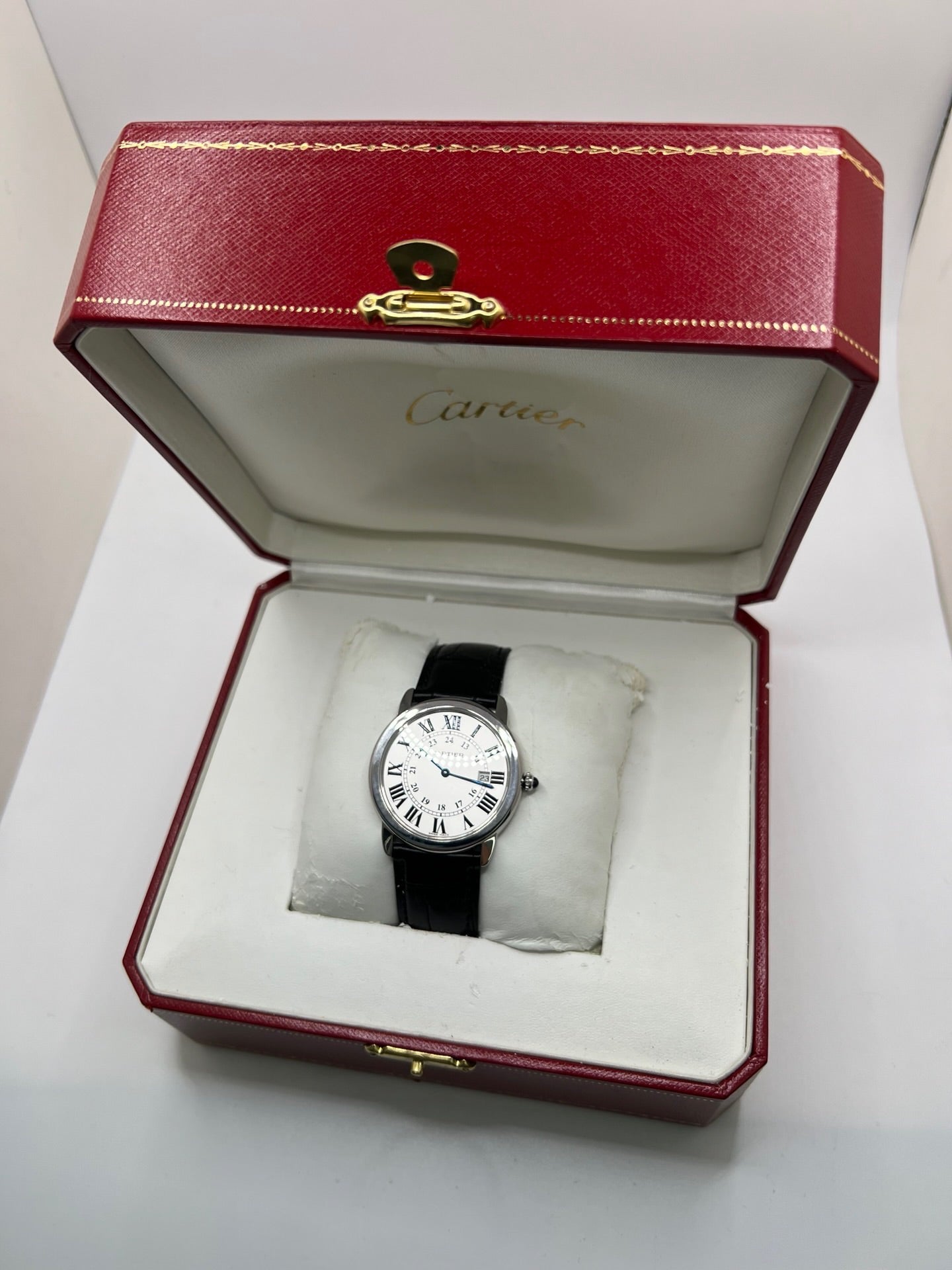 Montre Cartier Ronde Solo en acier avec cadran argent à chiffres romains, mouvement quartz et fonction date. Boîtier rond 36 x 39 mm avec verre saphir et étanchéité 3 ATM. Bracelet en cuir noir avec boucle ardillon en acier. Design classique et élégant, idéal pour homme ou unisexe. Montre d’occasion en très bon état, révisée, avec coffret d’origine.