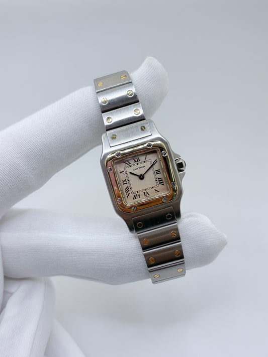 Montre Cartier Santos référence 1057930 en or et acier, équipée d’un mouvement à quartz. Ce modèle emblématique de la collection Santos présente un boîtier de 24 × 35 mm, un cadran blanc et un verre saphir. Son bracelet en or et acier s’accorde parfaitement avec son boîtier bicolore pour une allure élégante et intemporelle. Cette montre Cartier Santos séduit par son design iconique et son raffinement, idéale pour les amateurs de haute horlogerie.