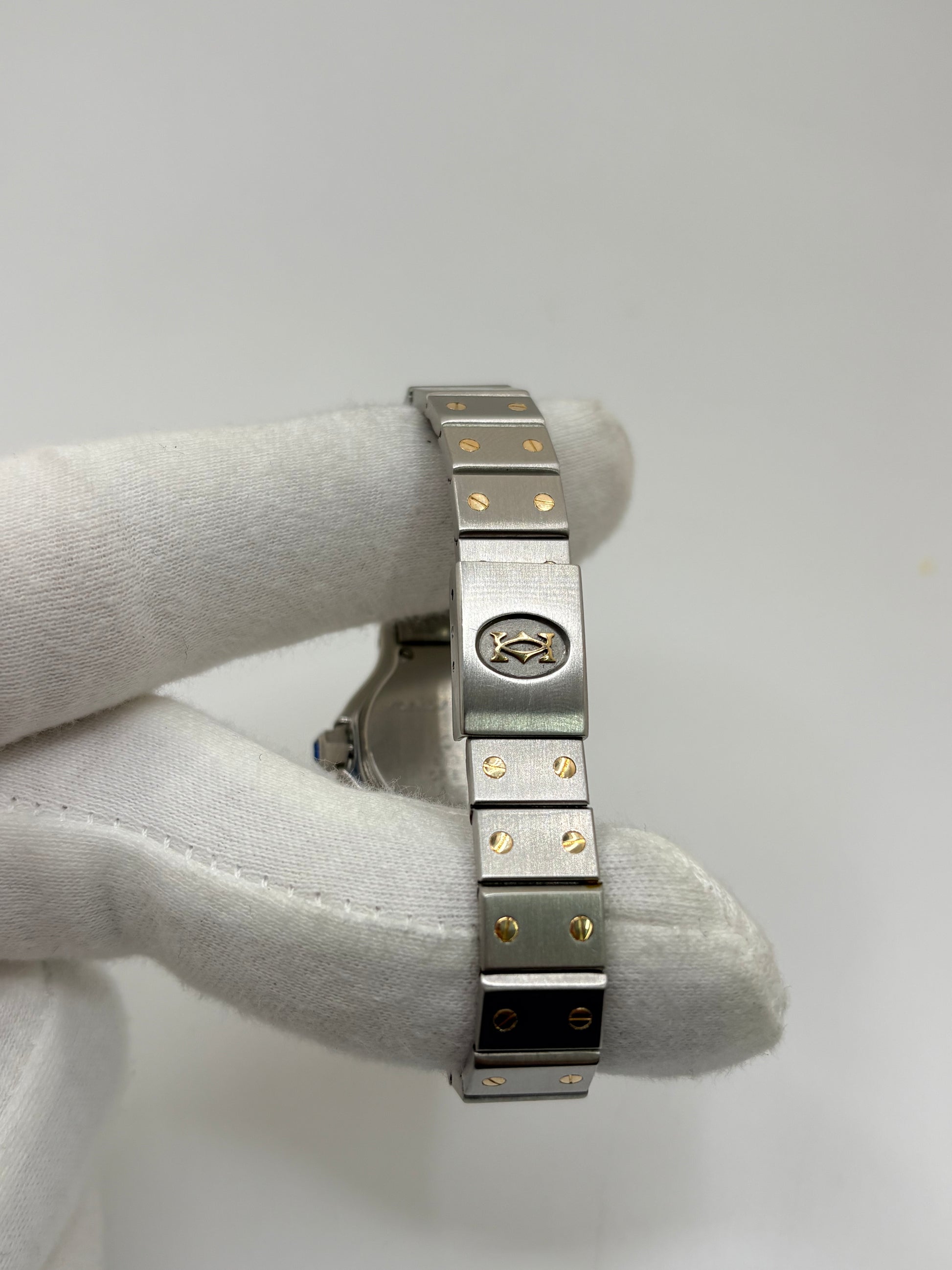 Montre Cartier Santos référence 187903 en or et acier avec boîtier de 24 x 31 mm, d'année inconnue et animée par un mouvement à quartz d'exception comptant 7 pierres. Son cadran blanc avec dateur est protégé par un verre saphir et complété par un bracelet en or et acier avec boucle pliante. Cette montre Cartier pour femme d'occasion est en très bon état, révisée en interne et livrée avec son coffret d'origine. Une pièce de luxe iconique disponible à Paris.