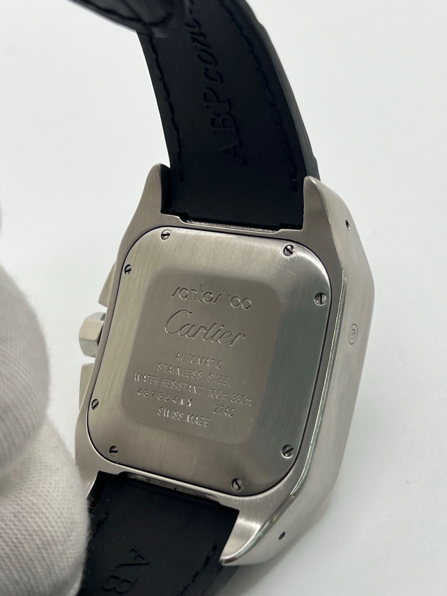 Montre Cartier Santos 100 XL Chronograph pour homme, modèle emblématique au design sport-chic. Boîtier en acier, cadran blanc à chiffres romains, bracelet en cuir noir. Mouvement automatique précis avec chronographe et date. Montre d’occasion en excellent état, révisée, livrée avec coffret d’origine.