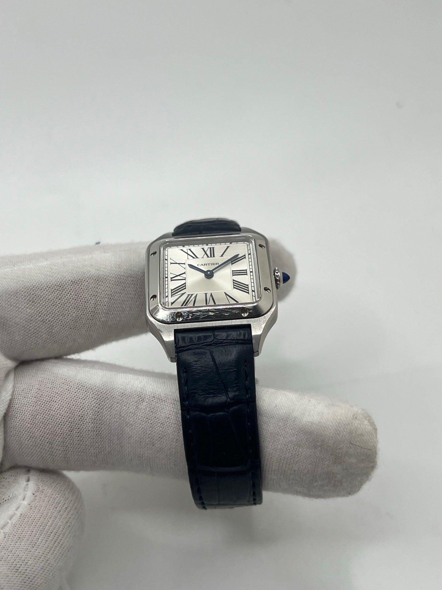 Montre élégante Santos Dumont en acier avec cadran argent et chiffres romains, équipée d’un mouvement quartz précis. Bracelet en cuir de crocodile bleu avec boucle ardillon en acier. Boîtier 38 x 27,5 mm, verre saphir et étanchéité 3 ATM. Design raffiné, idéal pour un style classique et sophistiqué. Disponible avec coffret et papiers d’origine.