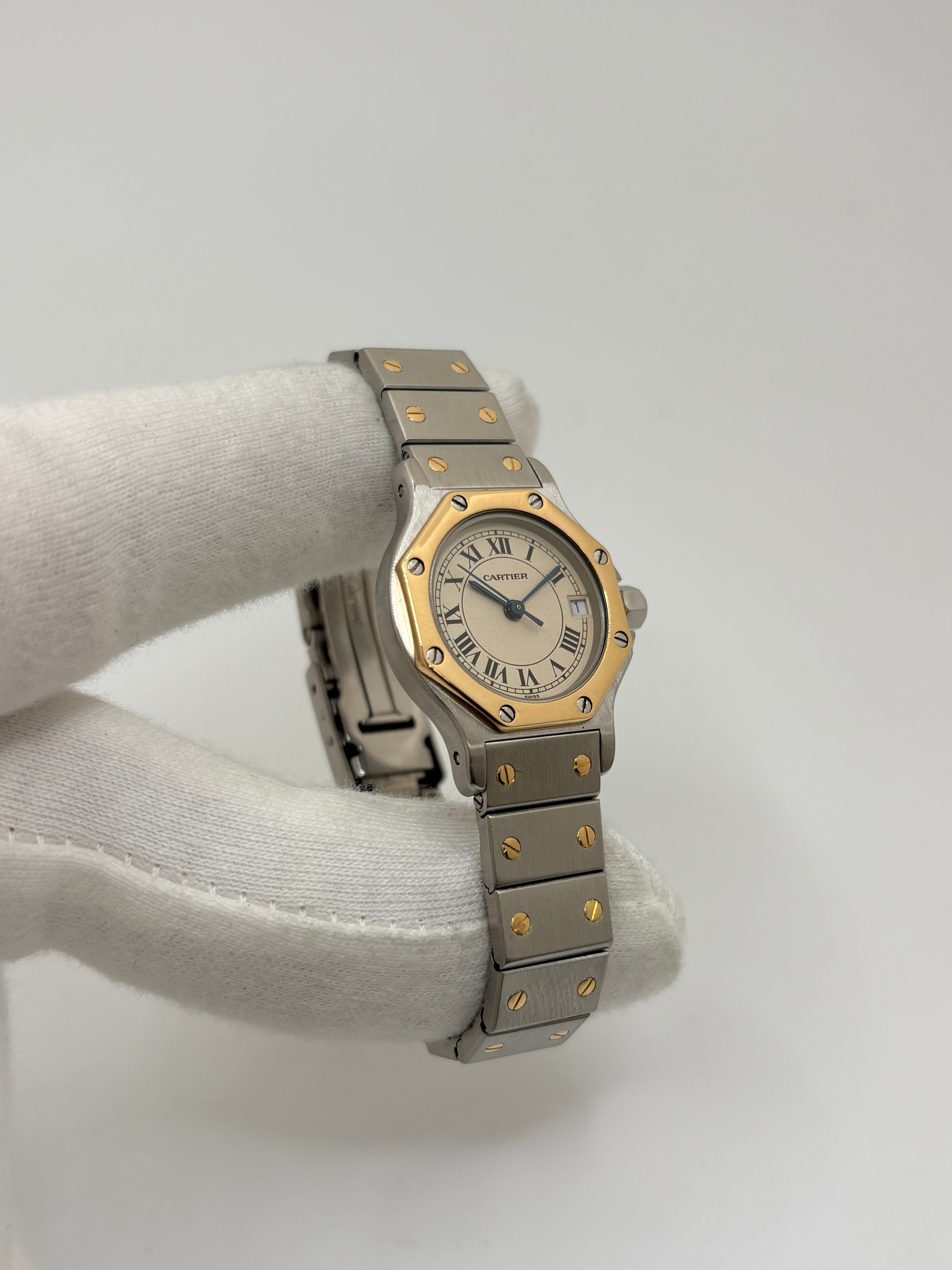 Montre Cartier Santos référence 187903 en or et acier avec boîtier de 24 x 31 mm, d'année inconnue et animée par un mouvement à quartz d'exception comptant 7 pierres. Son cadran blanc avec dateur est protégé par un verre saphir et complété par un bracelet en or et acier avec boucle pliante. Cette montre Cartier pour femme d'occasion est en très bon état, révisée en interne et livrée avec son coffret d'origine. Une pièce de luxe iconique disponible à Paris.