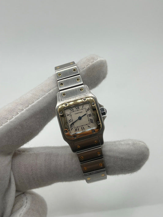 Montre Cartier Santos Galbée Lady référence 1057930 en or et acier, format 24 x 35 mm, équipée d’un mouvement quartz calibre 157. Modèle pour femme avec cadran blanc à chiffres romains, bracelet assorti et verre saphir. Pièce d’occasion en très bon état avec légères traces d’usage, livrée avec coffret d’origine.