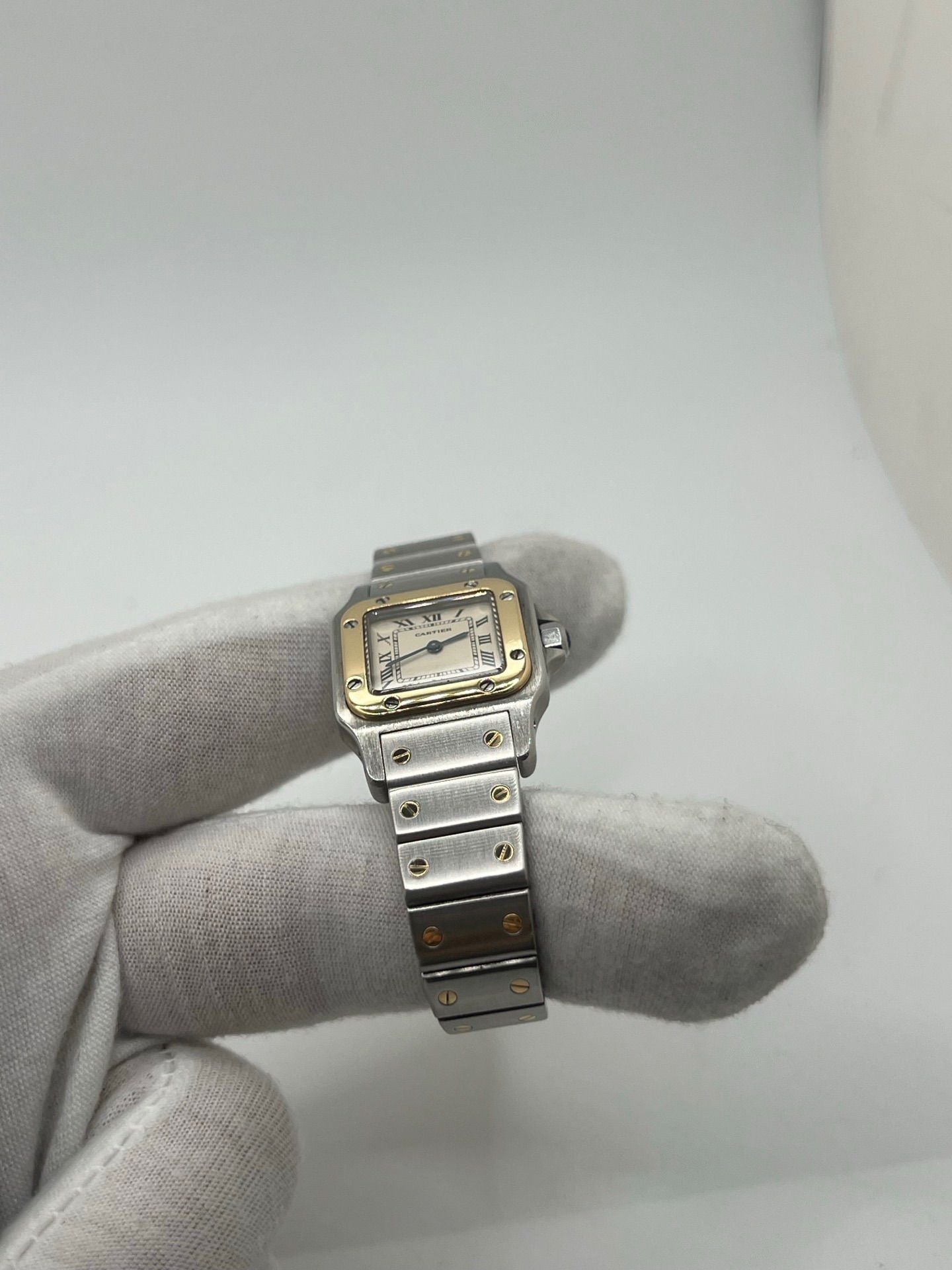 Montre Cartier Santos Galbée Lady référence 1057930 en or et acier, format 24 x 35 mm, équipée d’un mouvement quartz calibre 157. Modèle pour femme avec cadran blanc à chiffres romains, bracelet assorti et verre saphir. Pièce d’occasion en très bon état avec légères traces d’usage, livrée avec coffret d’origine.