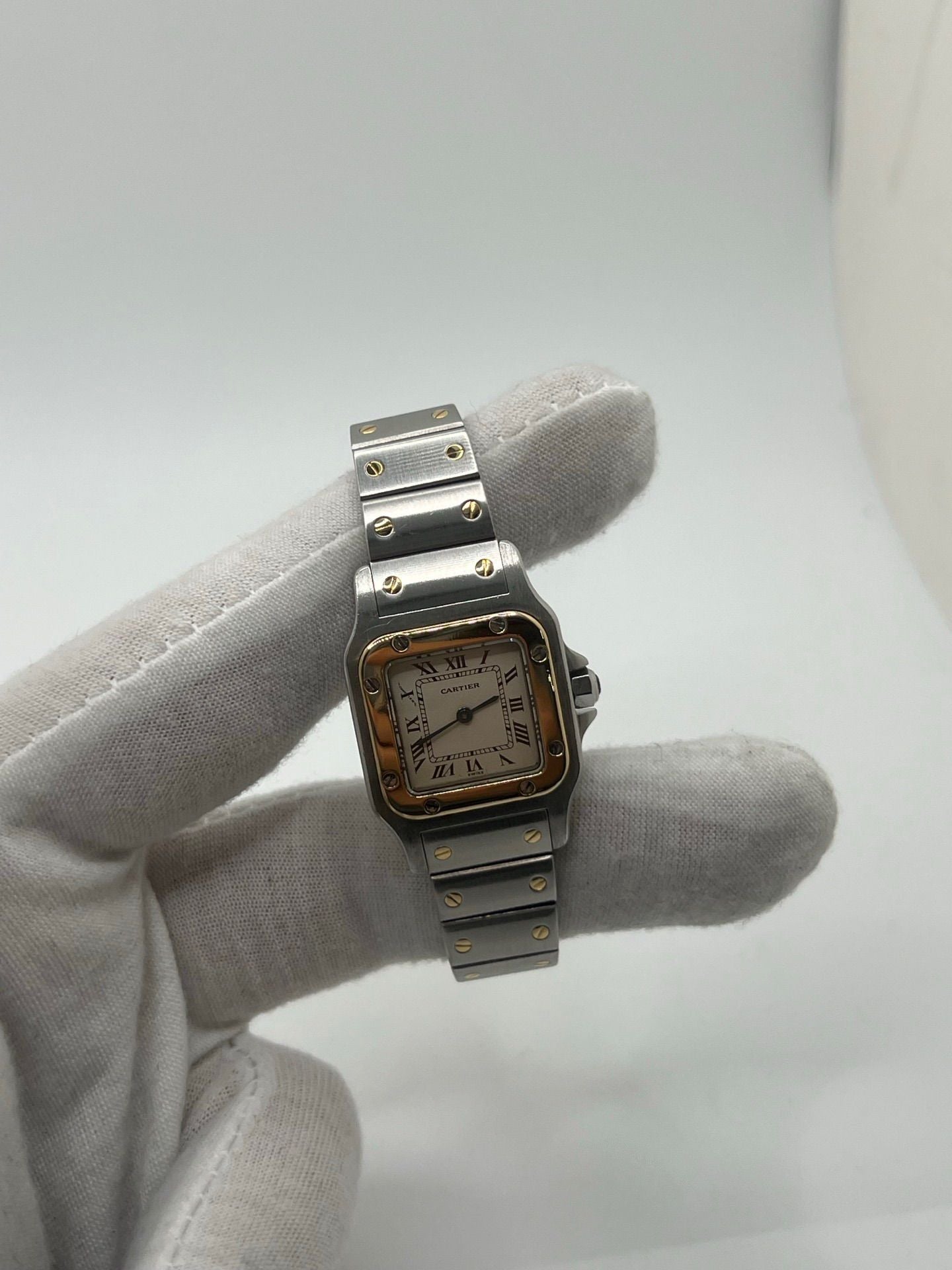 Montre Cartier Santos Galbée Lady référence 1057930 en or et acier, format 24 x 35 mm, équipée d’un mouvement quartz calibre 157. Modèle pour femme avec cadran blanc à chiffres romains, bracelet assorti et verre saphir. Pièce d’occasion en très bon état avec légères traces d’usage, livrée avec coffret d’origine.