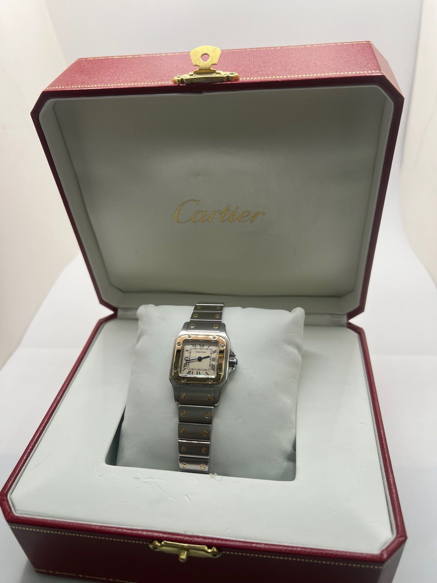 Montre Cartier Santos Galbée Lady référence 1057930 en or et acier, format 24 x 35 mm, équipée d’un mouvement quartz calibre 157. Modèle pour femme avec cadran blanc à chiffres romains, bracelet assorti et verre saphir. Pièce d’occasion en très bon état avec légères traces d’usage, livrée avec coffret d’origine.