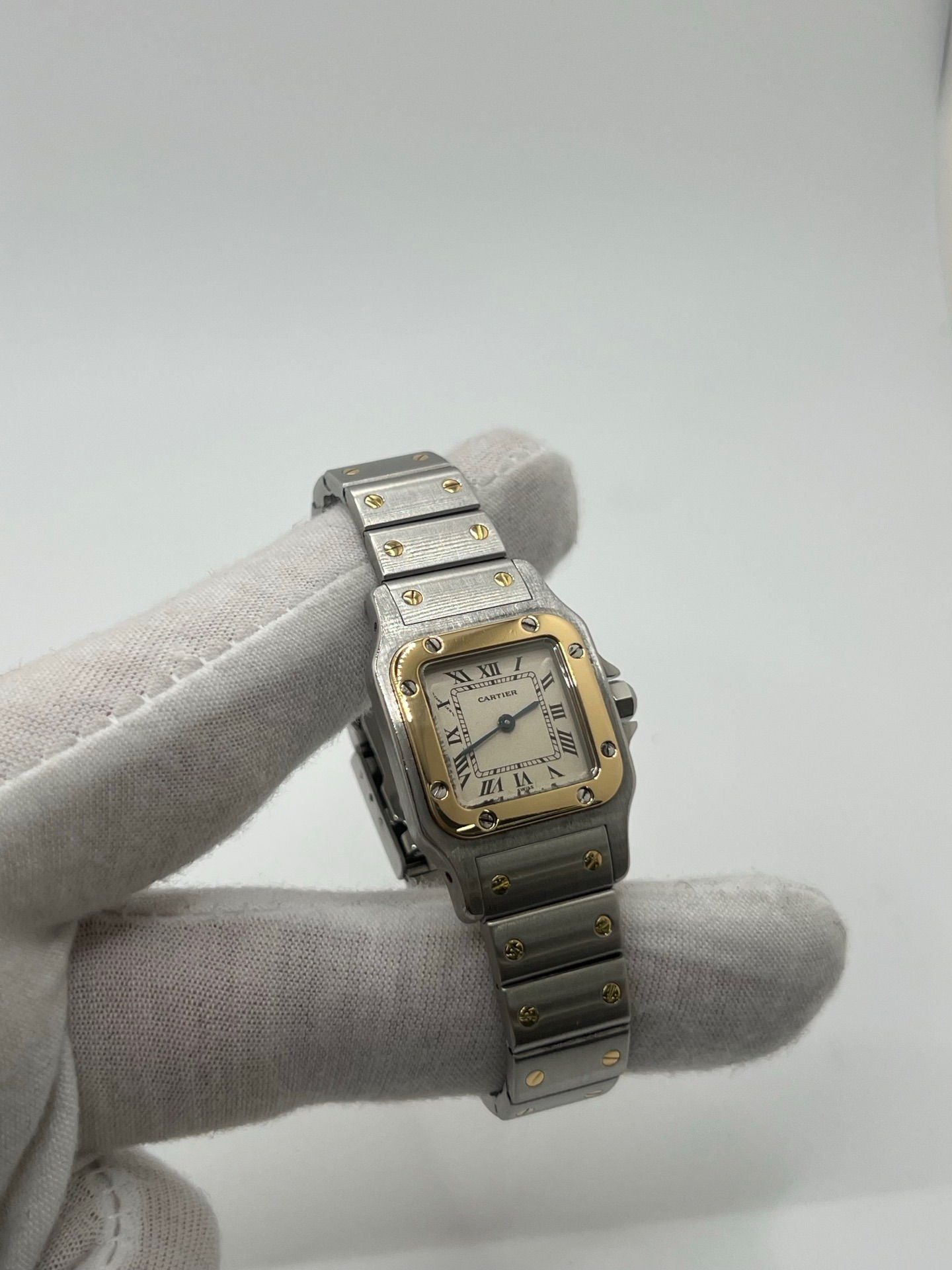 Montre Cartier Santos Galbée Lady référence 1057930 en or et acier, format 24 x 35 mm, équipée d’un mouvement quartz calibre 157. Modèle pour femme avec cadran blanc à chiffres romains, bracelet assorti et verre saphir. Pièce d’occasion en très bon état avec légères traces d’usage, livrée avec coffret d’origine.