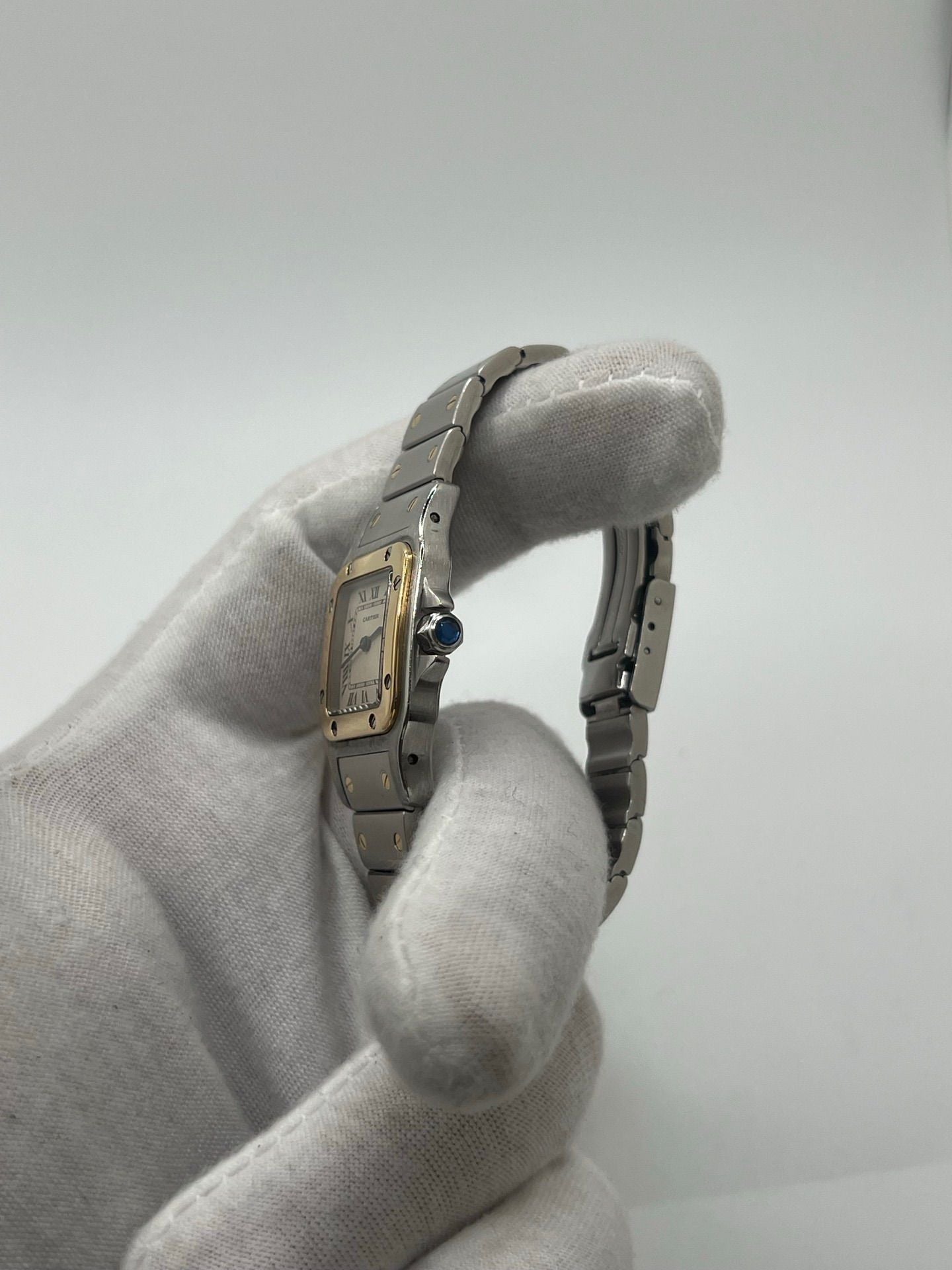 Montre Cartier Santos Galbée Lady référence 1057930 en or et acier, format 24 x 35 mm, équipée d’un mouvement quartz calibre 157. Modèle pour femme avec cadran blanc à chiffres romains, bracelet assorti et verre saphir. Pièce d’occasion en très bon état avec légères traces d’usage, livrée avec coffret d’origine.