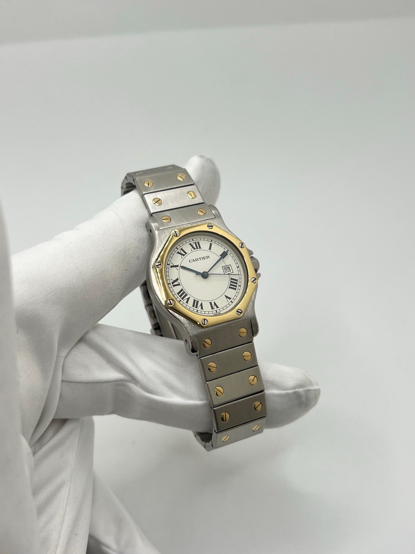 Montre Cartier Santos Octogonale 2966 en acier et or avec mouvement automatique, cadran blanc à chiffres romains et verre saphir. Modèle vintage élégant de 30 mm avec bracelet assorti et fonction date. Pièce d’occasion en très bon état, présentant de légères micro-rayures. Design iconique, idéal pour homme ou unisexe, livré avec coffret d’origine, disponible immédiatement à Paris.