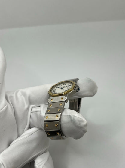 Montre Cartier Santos Octogonale 2966 en acier et or avec mouvement automatique, cadran blanc à chiffres romains et verre saphir. Modèle vintage élégant de 30 mm avec bracelet assorti et fonction date. Pièce d’occasion en très bon état, présentant de légères micro-rayures. Design iconique, idéal pour homme ou unisexe, livré avec coffret d’origine, disponible immédiatement à Paris.