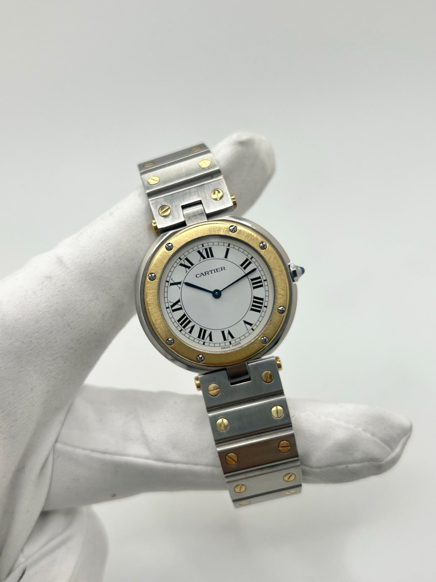 Montre Cartier Santos Ronde d'occasion en très bon état, boîtier or/acier de 33 mm avec lunette en or jaune et cadran blanc à chiffres romains. Mouvement quartz précis, verre saphir résistant aux rayures. Bracelet assorti or/acier avec boucle du même matériau. Livrée avec coffret d’origine, sans papiers. Parfaite pour collectionneurs ou amateurs de montres élégantes, disponible en stock à Paris, prix négociable