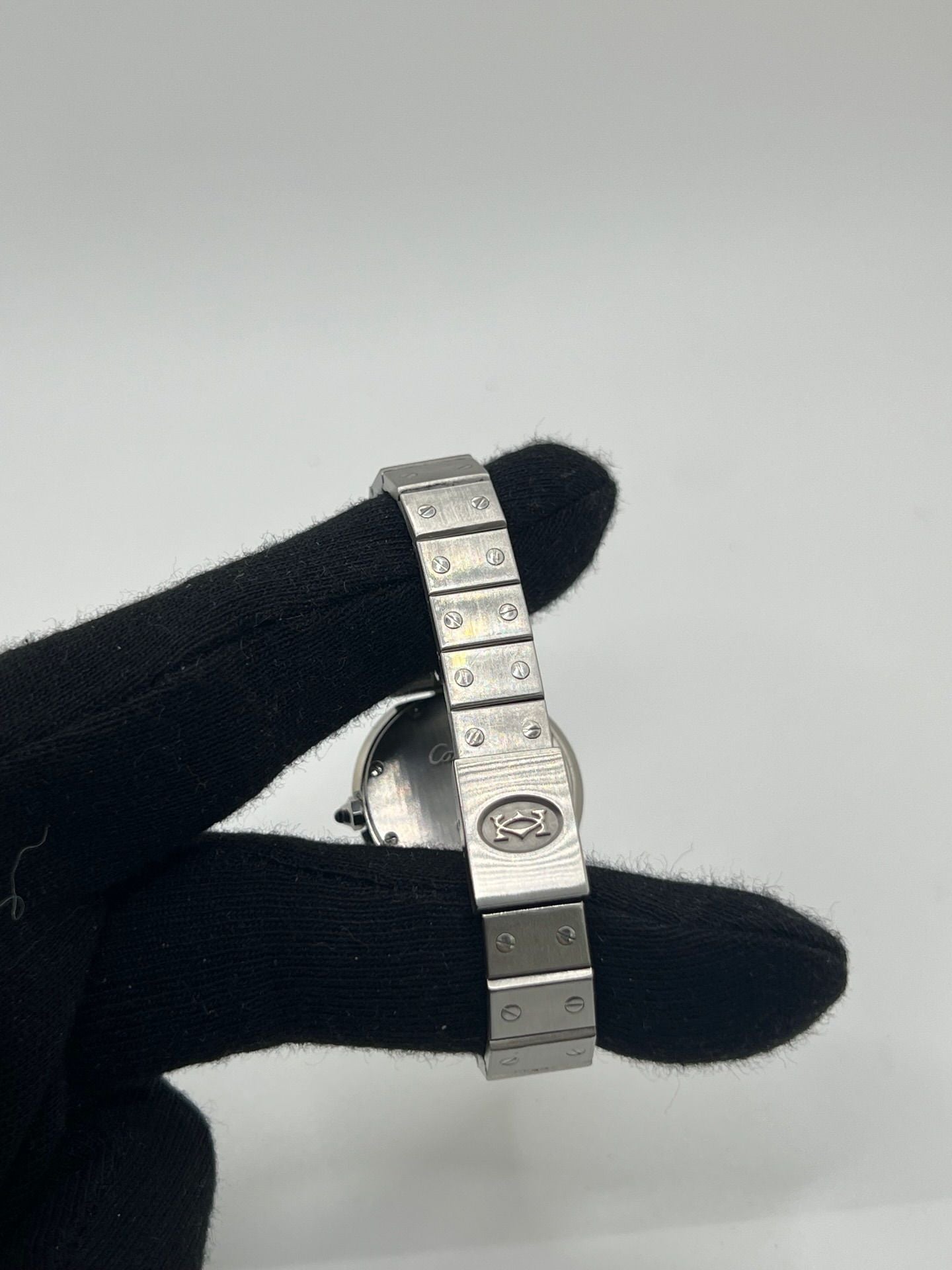 Montre Cartier Santos Vendôme référence 8192 en acier, modèle pour femme avec boîtier rond de 27 mm, cadran blanc à chiffres romains et mouvement quartz. Bracelet acier assorti, boucle à plis et verre saphir. Montre vintage de 1981 en très bon état, livrée avec coffret et papiers d’origine.