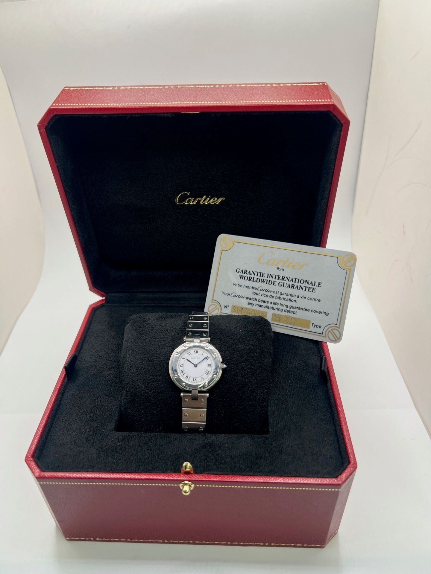 Montre Cartier Santos Vendôme référence 8192 en acier, modèle pour femme avec boîtier rond de 27 mm, cadran blanc à chiffres romains et mouvement quartz. Bracelet acier assorti, boucle à plis et verre saphir. Montre vintage de 1981 en très bon état, livrée avec coffret et papiers d’origine.