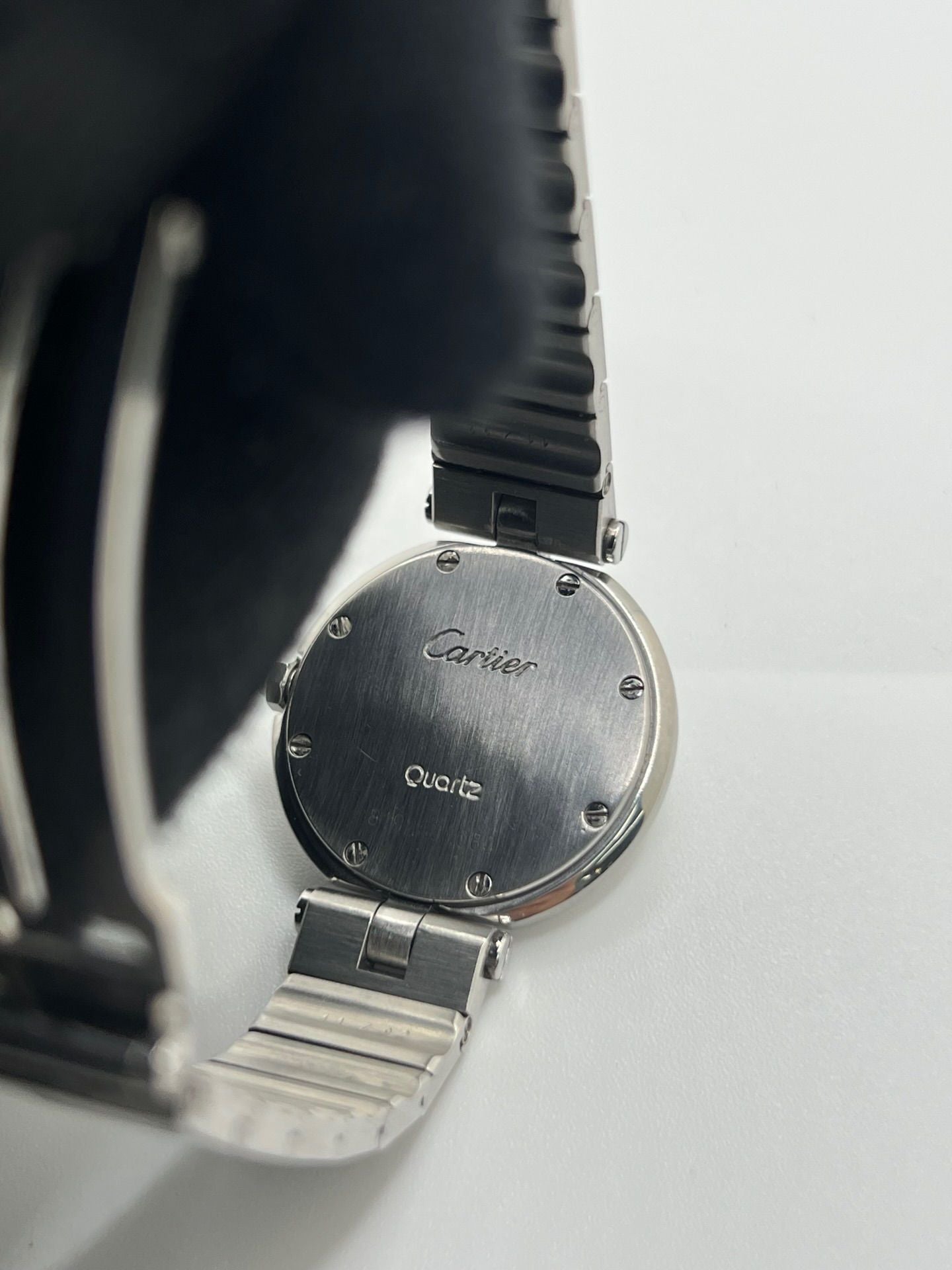 Montre Cartier Santos Vendôme référence 8192 en acier, modèle pour femme avec boîtier rond de 27 mm, cadran blanc à chiffres romains et mouvement quartz. Bracelet acier assorti, boucle à plis et verre saphir. Montre vintage de 1981 en très bon état, livrée avec coffret et papiers d’origine.