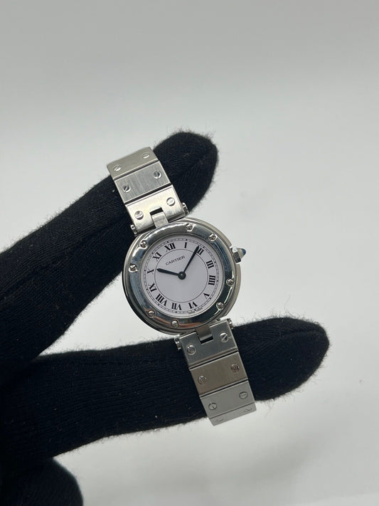 Montre Cartier Santos Vendôme référence 8192 en acier, modèle pour femme avec boîtier rond de 27 mm, cadran blanc à chiffres romains et mouvement quartz. Bracelet acier assorti, boucle à plis et verre saphir. Montre vintage de 1981 en très bon état, livrée avec coffret et papiers d’origine.