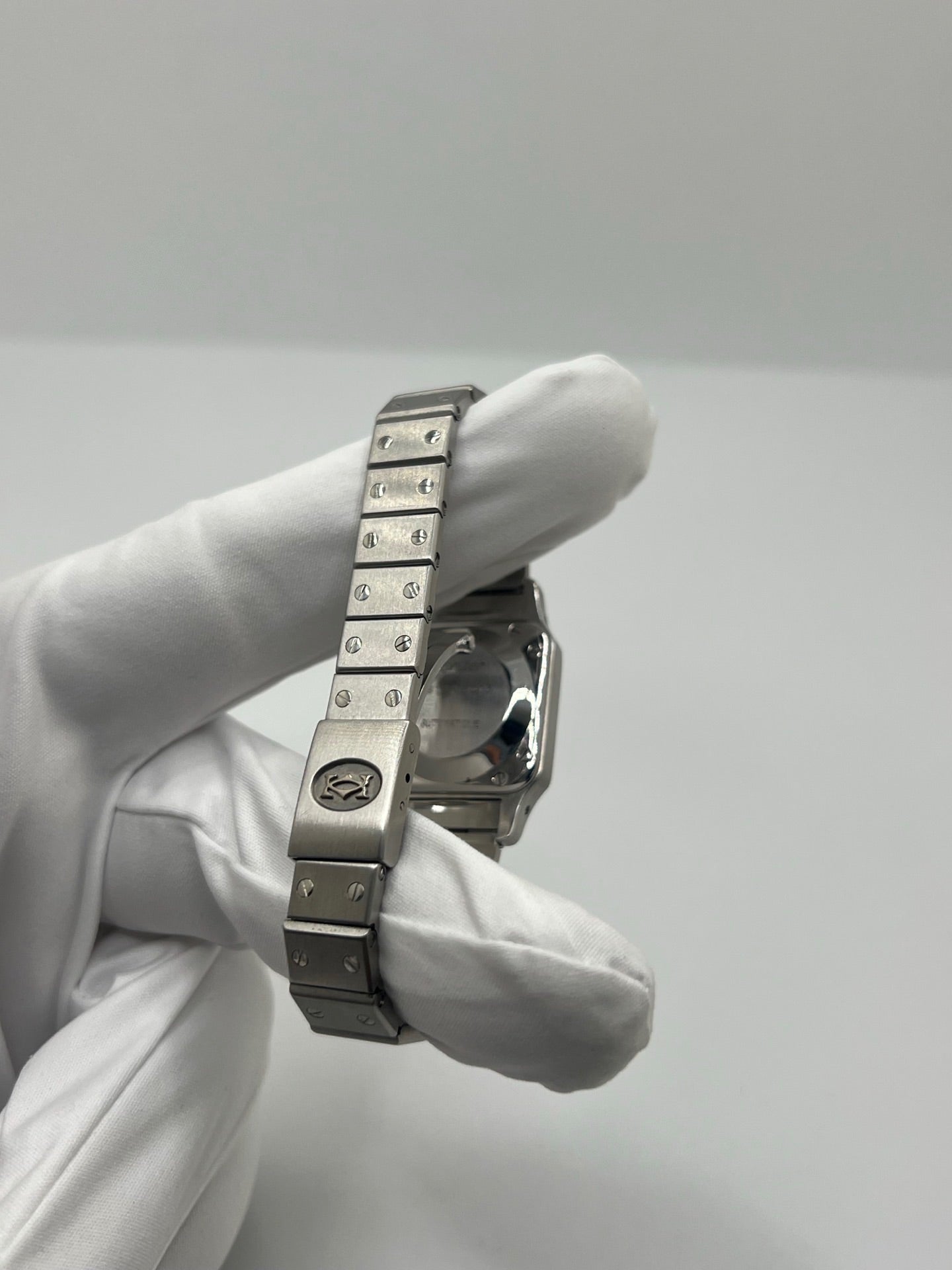 Montre Cartier Santos Lady en acier pour femme, modèle vintage à remontage automatique avec cadran blanc à chiffres romains, boîtier rectangulaire 24 x 35 mm, verre saphir et bracelet acier. Cette montre d’occasion en très bon état présente de légères traces d’usure discrètes. Livrée avec son coffret d’origine, sans papiers, cette Cartier Santos Lady allie élégance intemporelle, raffinement horloger et style iconique pour une collection de montres de luxe femme.