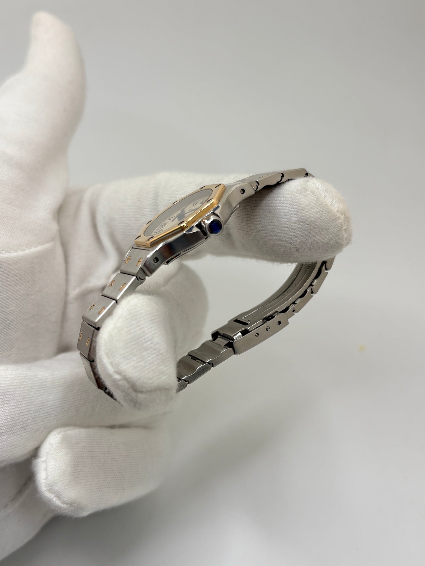 Montre Cartier Santos référence 187903 en or et acier avec boîtier de 24 x 31 mm, d'année inconnue et animée par un mouvement à quartz d'exception comptant 7 pierres. Son cadran blanc avec dateur est protégé par un verre saphir et complété par un bracelet en or et acier avec boucle pliante. Cette montre Cartier pour femme d'occasion est en très bon état, révisée en interne et livrée avec son coffret d'origine. Une pièce de luxe iconique disponible à Paris.