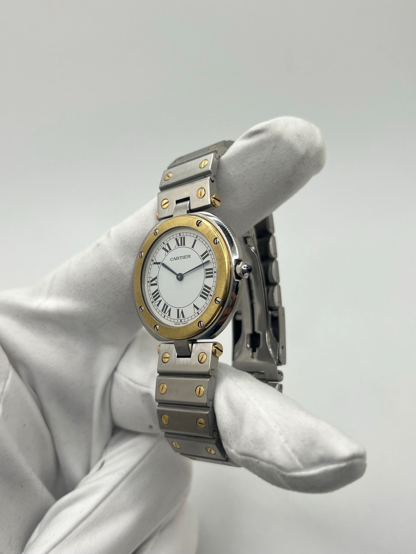 Montre Cartier Santos Ronde d'occasion en très bon état, boîtier or/acier de 33 mm avec lunette en or jaune et cadran blanc à chiffres romains. Mouvement quartz précis, verre saphir résistant aux rayures. Bracelet assorti or/acier avec boucle du même matériau. Livrée avec coffret d’origine, sans papiers. Parfaite pour collectionneurs ou amateurs de montres élégantes, disponible en stock à Paris, prix négociable