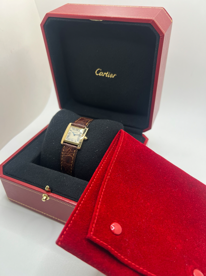 Montre Cartier Tank Française référence 1820 en or jaune 18K, petit modèle pour femme, boîtier rectangulaire emblématique aux lignes droites et élégantes, cadran blanc avec chiffres romains noirs, minuterie chemin de fer et aiguilles bleuies en forme de glaive. Bracelet intégré en acier avec boucle déployante. Mouvement quartz précis. Montre de luxe intemporelle, raffinée et iconique, idéale pour un porté quotidien ou une tenue habillée.
