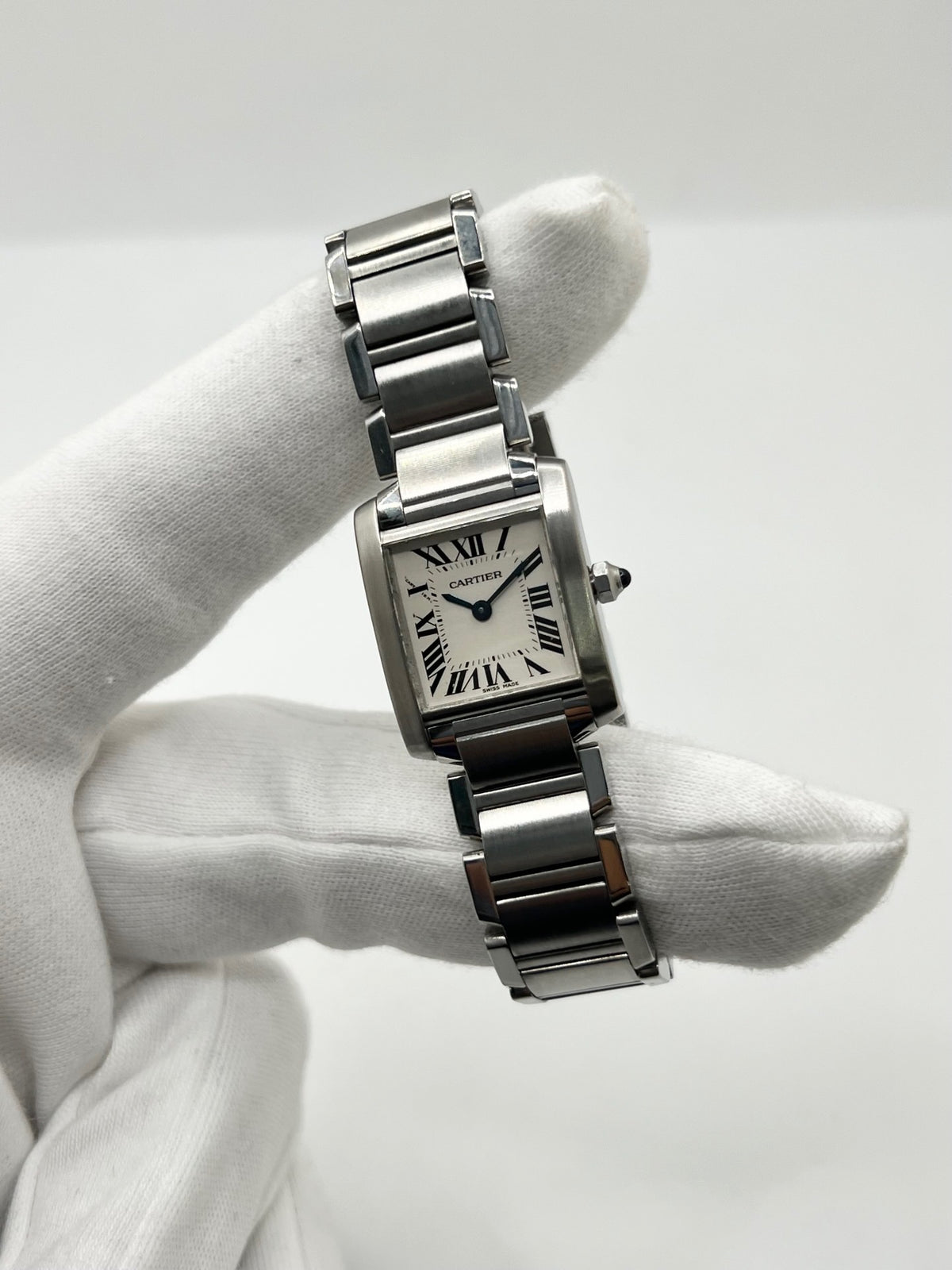 Montre Cartier Tank Française 2384 pour femme, dotée d’un mouvement à quartz et d’un boîtier rectangulaire en acier de 20 × 25 mm. Son cadran blanc est protégé par un verre saphir, tandis que son bracelet en acier avec boucle déployante double apporte une finition élégante et raffinée. D’une hauteur de 6 mm et étanche à 3 ATM, cette Cartier Tank Française incarne le style intemporel de la Maison. Modèle en très bon état, vendu avec son coffret d’origine.