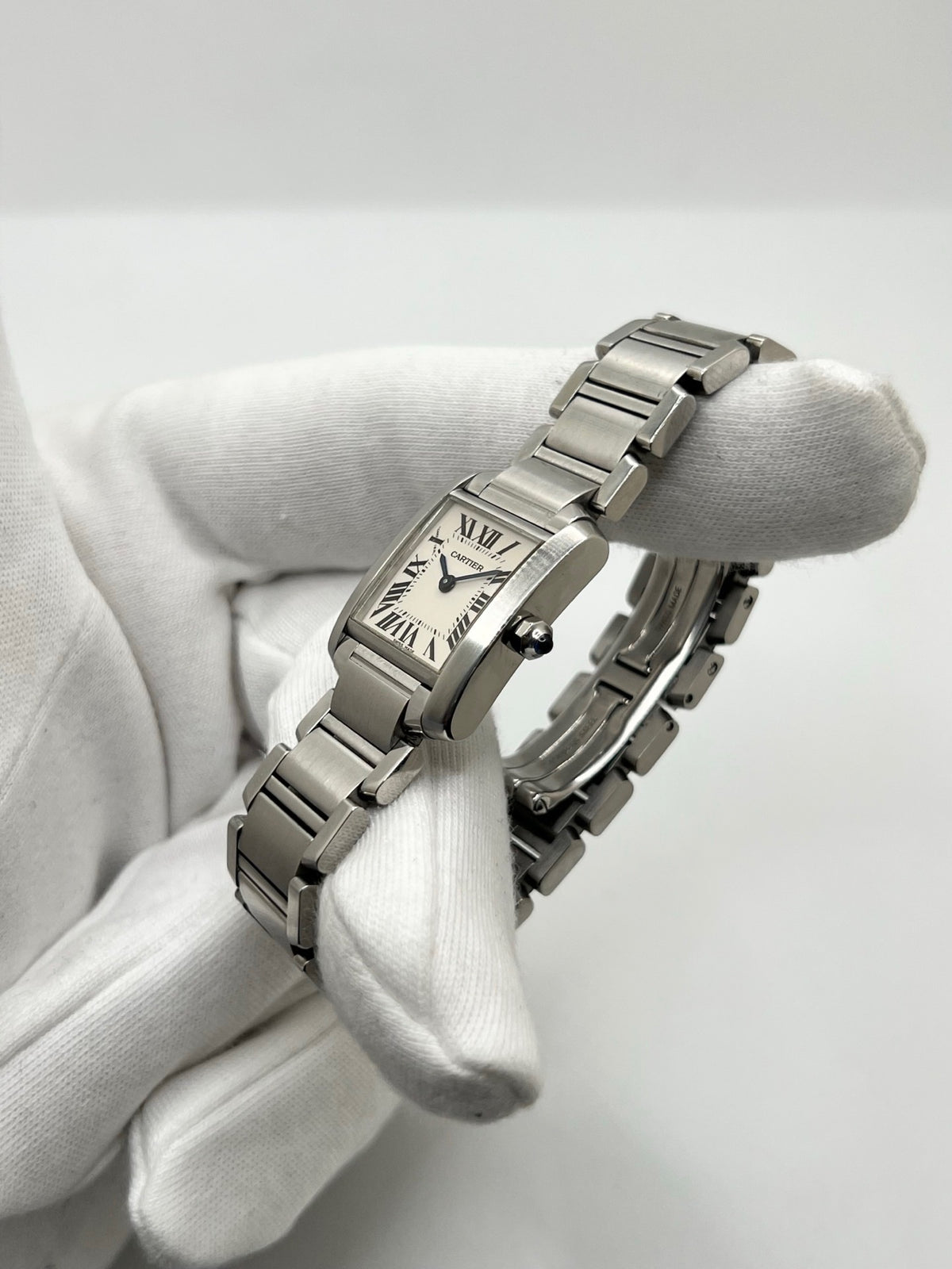 Montre Cartier Tank Française 2384 pour femme, dotée d’un mouvement à quartz et d’un boîtier rectangulaire en acier de 20 × 25 mm. Son cadran blanc est protégé par un verre saphir, tandis que son bracelet en acier avec boucle déployante double apporte une finition élégante et raffinée. D’une hauteur de 6 mm et étanche à 3 ATM, cette Cartier Tank Française incarne le style intemporel de la Maison. Modèle en très bon état, vendu avec son coffret d’origine.