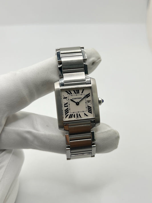 Montre Cartier Tank Française 2465 pour femme en acier, dotée d’un mouvement quartz et d’un cadran blanc à chiffres romains. Ce modèle iconique présente un boîtier de 25 x 30 mm, un bracelet en acier avec boucle double plis, ainsi qu’un verre saphir. Montre de luxe d’occasion en très bon état, avec de légères traces d’usure discrètes. Livrée avec son coffret d’origine, sans papiers, révisée en interne en mars 2026.