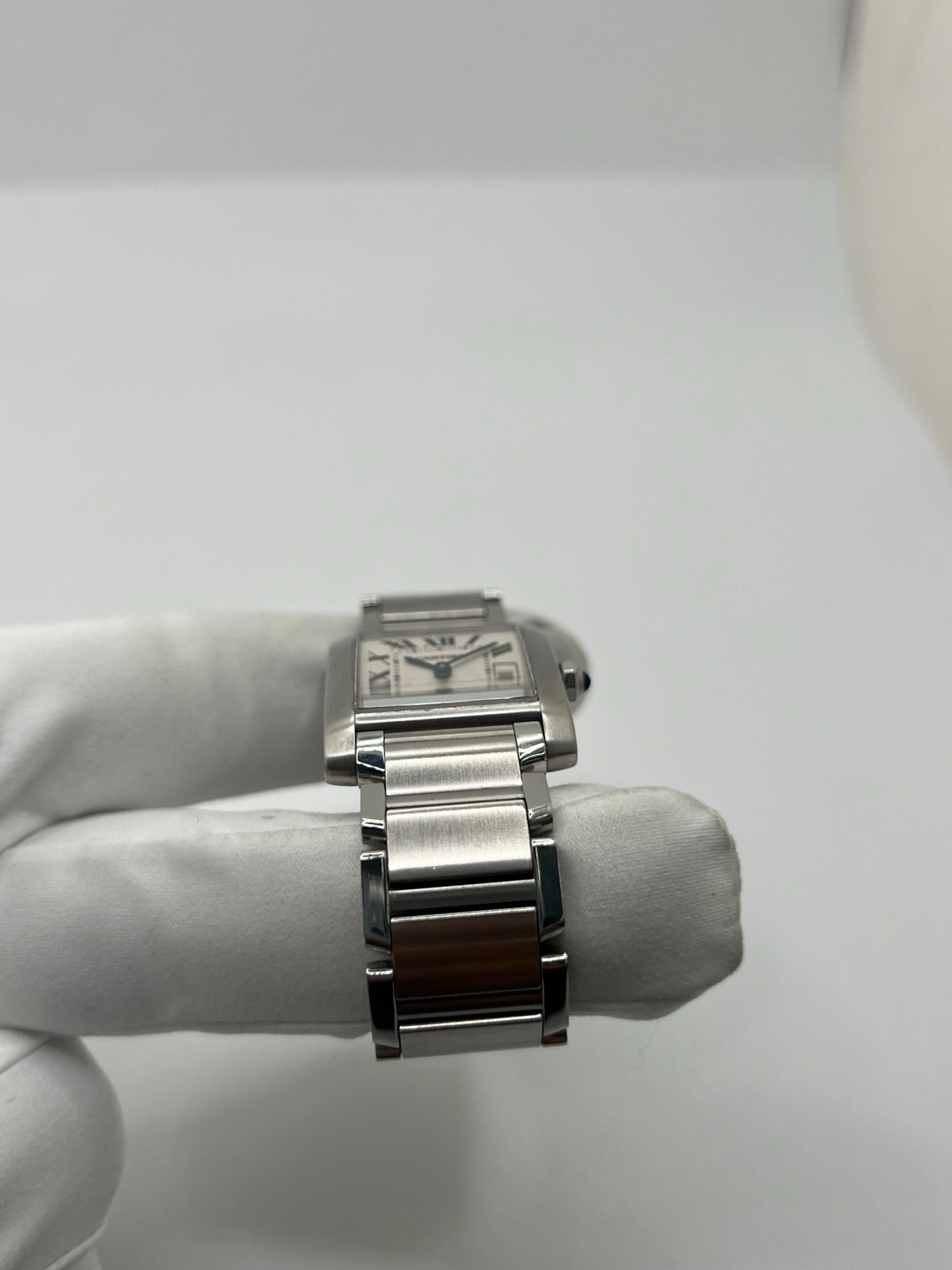 Montre Cartier Tank Française 2465 pour femme en acier, dotée d’un mouvement quartz et d’un cadran blanc à chiffres romains. Ce modèle iconique présente un boîtier de 25 x 30 mm, un bracelet en acier avec boucle double plis, ainsi qu’un verre saphir. Montre de luxe d’occasion en très bon état, avec de légères traces d’usure discrètes. Livrée avec son coffret d’origine, sans papiers, révisée en interne en mars 2026.