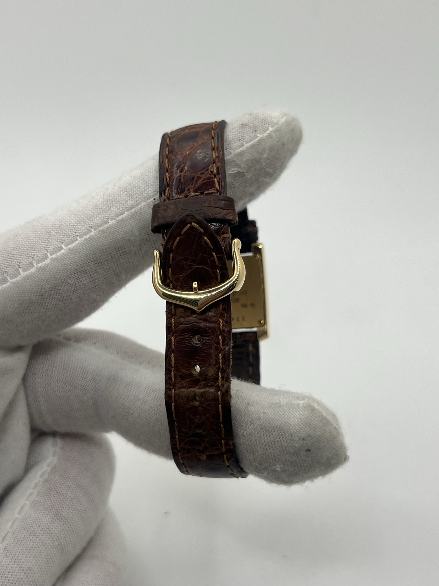 Montre Cartier Tank Française référence 1820 en or jaune 18K, petit modèle pour femme, boîtier rectangulaire emblématique aux lignes droites et élégantes, cadran blanc avec chiffres romains noirs, minuterie chemin de fer et aiguilles bleuies en forme de glaive. Bracelet intégré en acier avec boucle déployante. Mouvement quartz précis. Montre de luxe intemporelle, raffinée et iconique, idéale pour un porté quotidien ou une tenue habillée.