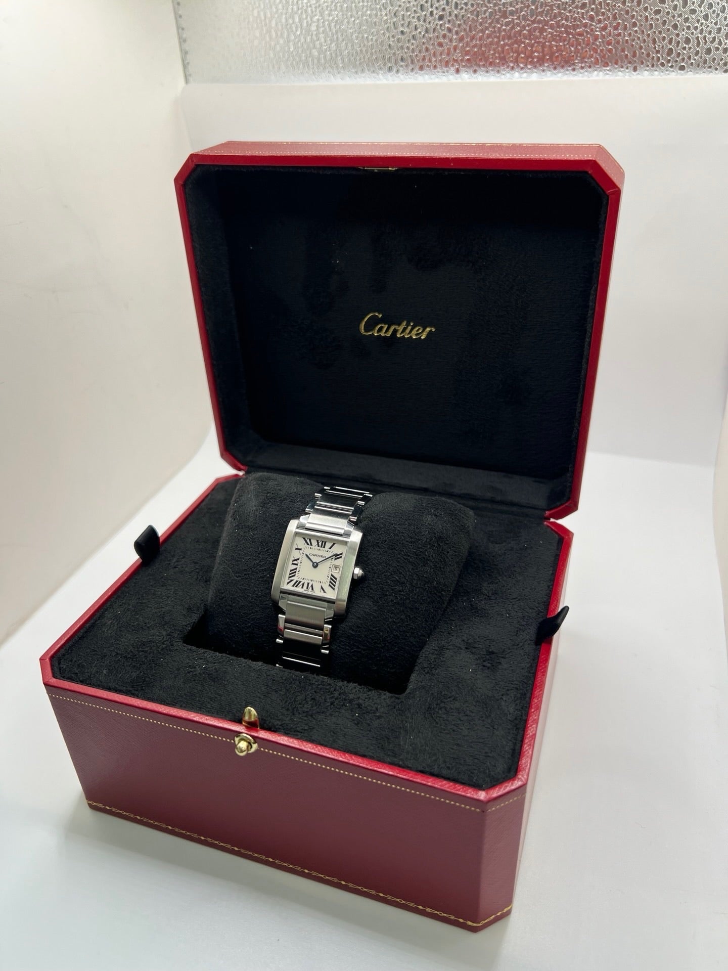 Montre Cartier Tank Française 2465 pour femme en acier, dotée d’un mouvement quartz et d’un cadran blanc à chiffres romains. Ce modèle iconique présente un boîtier de 25 x 30 mm, un bracelet en acier avec boucle double plis, ainsi qu’un verre saphir. Montre de luxe d’occasion en très bon état, avec de légères traces d’usure discrètes. Livrée avec son coffret d’origine, sans papiers, révisée en interne en mars 2026.