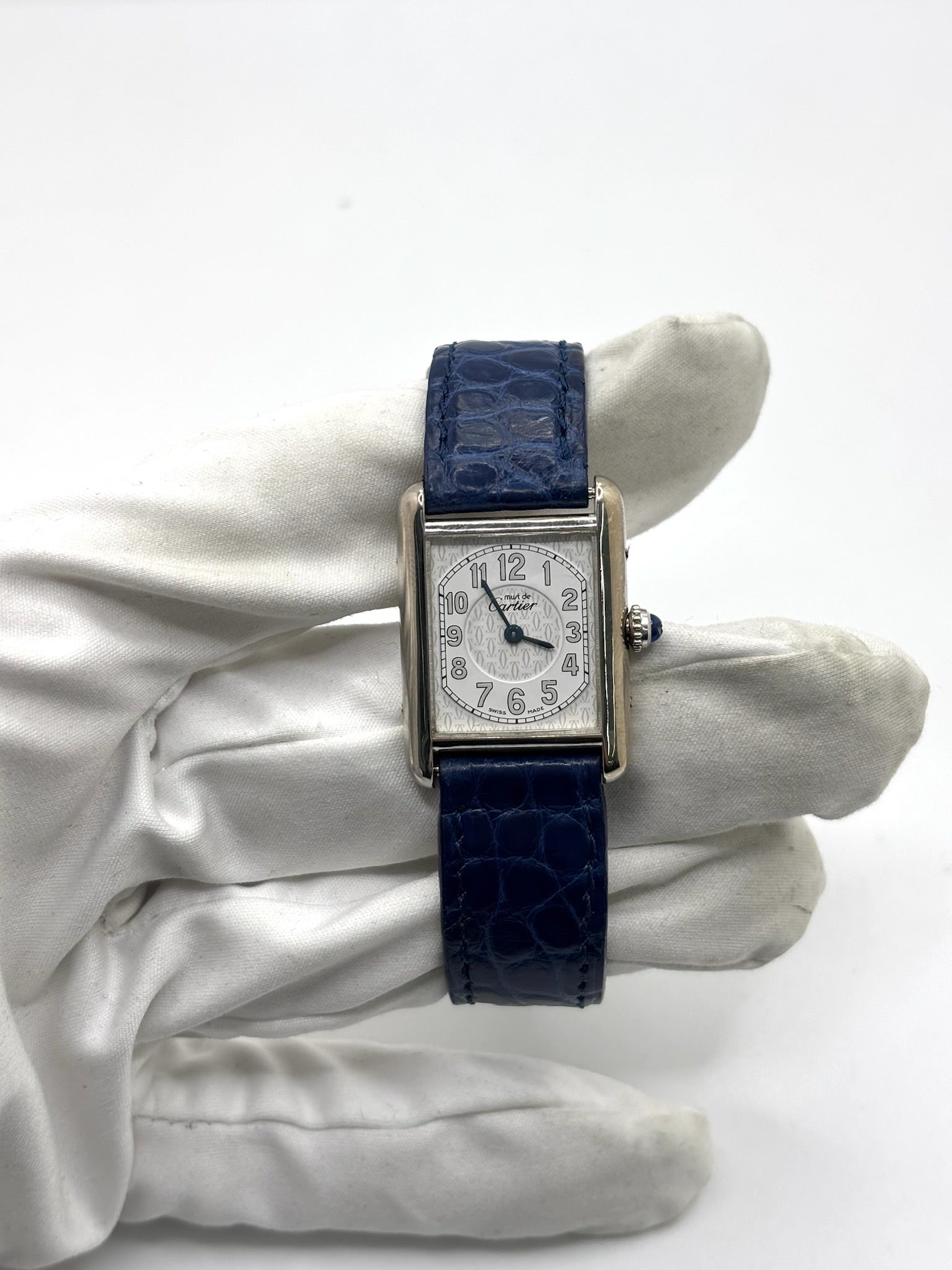 Montre Cartier Tank Must référence 2416 en argent avec cadran blanc à chiffres arabes et mouvement quartz. Ce modèle iconique présente un boîtier rectangulaire de 22 x 30 mm, une lunette en argent et un bracelet en cuir bleu avec boucle ardillon en acier. Cartier Tank Must d'occasion en très bon état, avec de légères traces d'usure. Montre homme ou unisexe élégante et intemporelle, idéale pour les amateurs d'horlogerie et de montres de luxe vintage.
