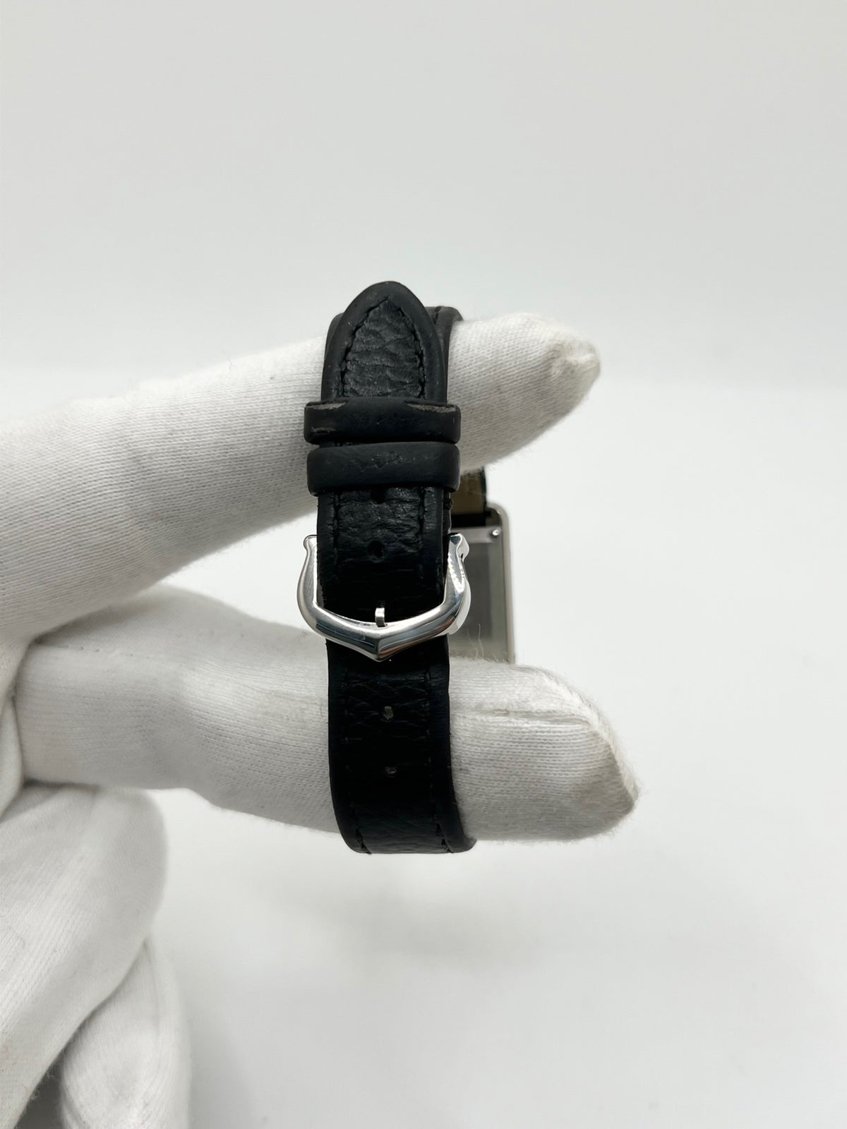 Montre Cartier Tank Must PM WSTA0042 pour femme, modèle élégant de la collection Tank datant de 2021. Cette montre de luxe se distingue par son boîtier rectangulaire en acier de 22 x 29 mm, son cadran argenté, son verre saphir et son bracelet en cuir noir. Équipée d’un mouvement à quartz, la Cartier Tank Must PM allie sobriété et élégance intemporelle. Proposée d’occasion en très bon état, elle est vendue avec son coffret d’origine et a bénéficié d’une révision interne le 19 octobre 2026.