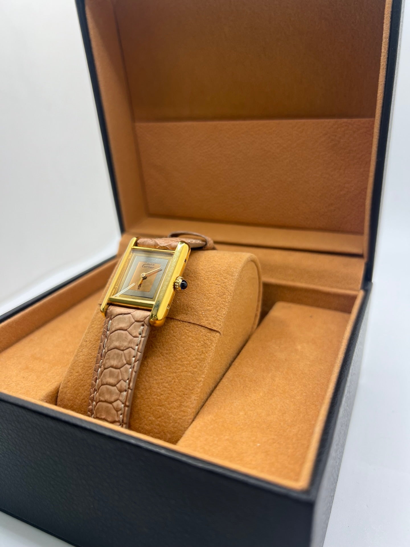 Montre femme Tank Must Vermeil Trinity référence 3 66001, boîtier en argent aux dimensions 21 x 28 mm, mouvement mécanique à remontage manuel. Cadran de couleur or sans chiffres, verre minéral, lunette en argent. Bracelet en cuir beige avec boucle ardillon en acier. Montre d’occasion en très bon état, présentant de légères traces d’usure superficielles non perceptibles au toucher. Modèle emblématique au design rectangulaire élégant.