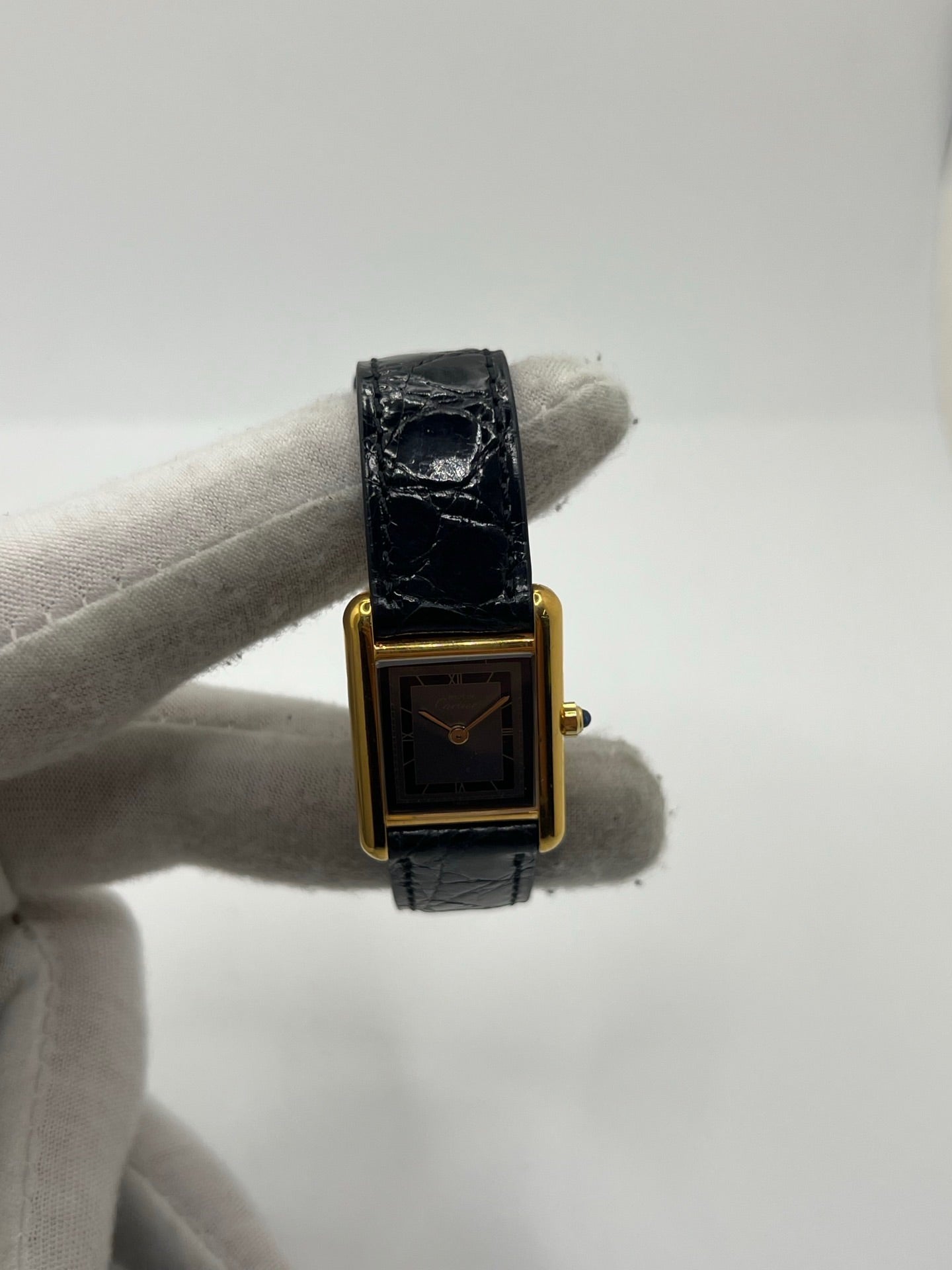 Montre Cartier Tank Vermeil 3 66001 pour femme, équipée d’un mouvement quartz et d’un boîtier en argent de 20 x 27 mm. Ce modèle d’occasion en très bon état présente un cadran or à chiffres romains, un verre minéral et un bracelet en cuir de crocodile noir avec boucle en acier. Élégante et intemporelle, la Cartier Tank Vermeil 3 66001 séduit par son design classique, idéale pour les passionnées de montres de luxe raffinées.