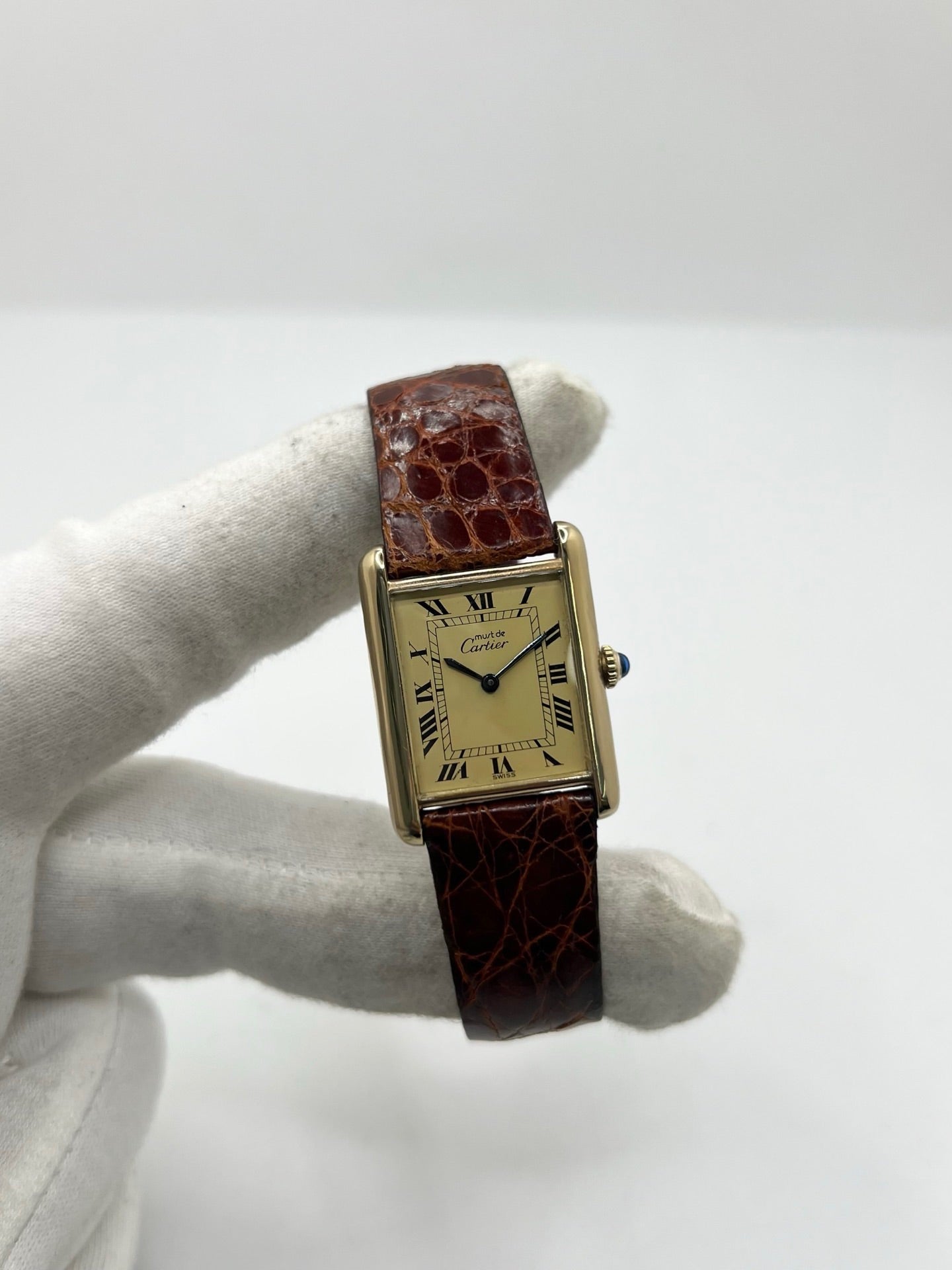 Cartier Tank Must Vermeil en argent avec boîtier rectangulaire de 23 x 30 mm, mouvement à remontage manuel et cadran champagne à chiffres romains. Cette montre unisexe est équipée d’un bracelet en cuir brun avec boucle ardillon en acier et d’un verre saphir. Modèle d’occasion en très bon état, révisé en interne en 2026. Une montre Cartier élégante et intemporelle, livrée avec coffret d’origine, sans papiers d’origine.
