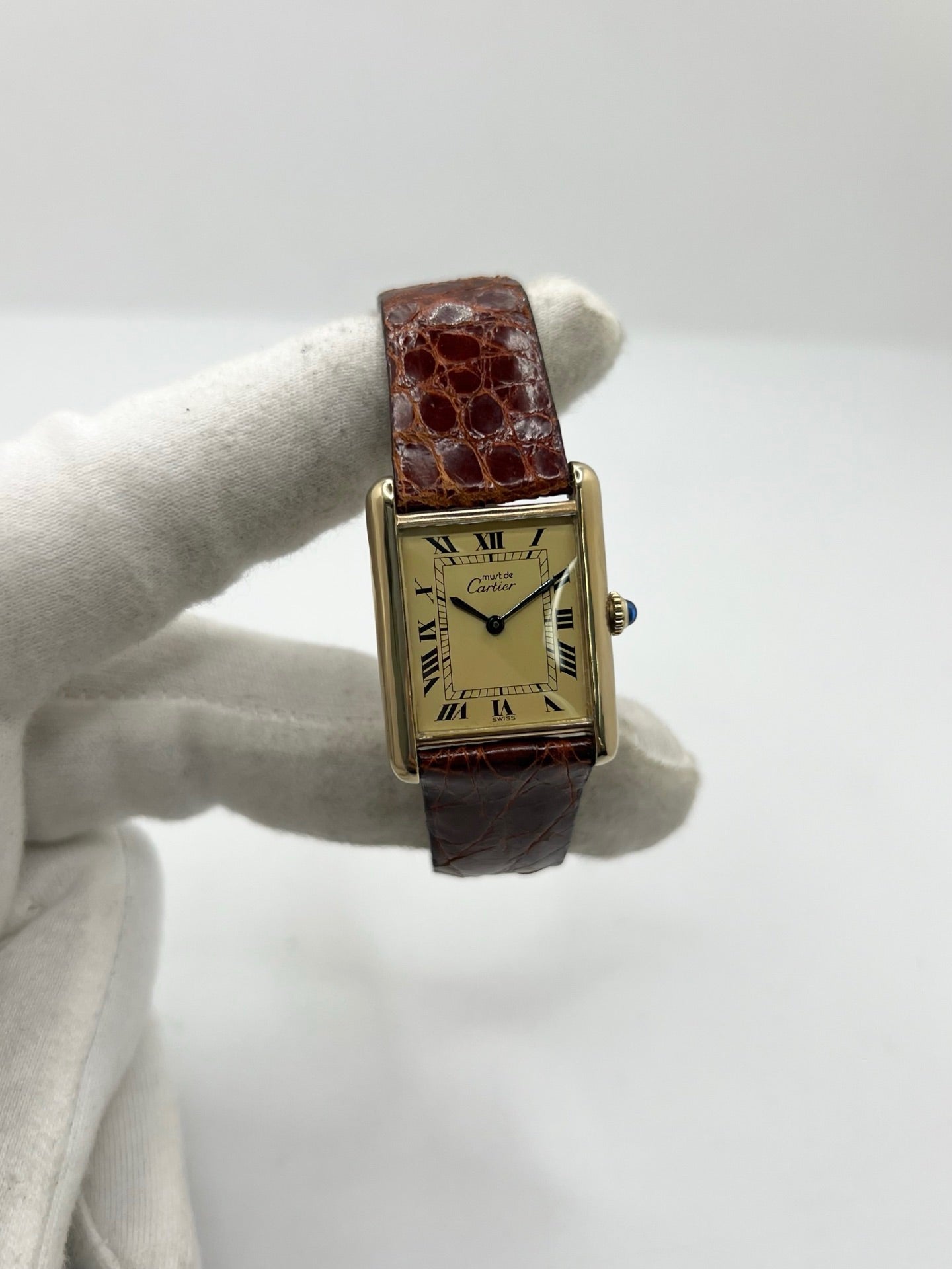 Cartier Tank Must Vermeil en argent avec boîtier rectangulaire de 23 x 30 mm, mouvement à remontage manuel et cadran champagne à chiffres romains. Cette montre unisexe est équipée d’un bracelet en cuir brun avec boucle ardillon en acier et d’un verre saphir. Modèle d’occasion en très bon état, révisé en interne en 2026. Une montre Cartier élégante et intemporelle, livrée avec coffret d’origine, sans papiers d’origine.
