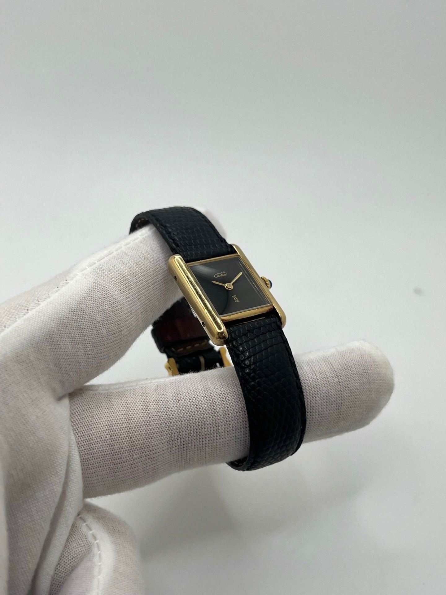 Montre Cartier Tank Must Vermeil référence 5057001 pour femme, boîtier en argent 20 x 28 mm, cadran noir sans chiffres et bracelet en cuir de lézard noir. Modèle à mouvement quartz, en bon état avec traces d’usure légères. Montre élégante au style intemporel, idéale pour un look sophistiqué et raffiné. Parfaite pour les amateurs de pièces vintage.