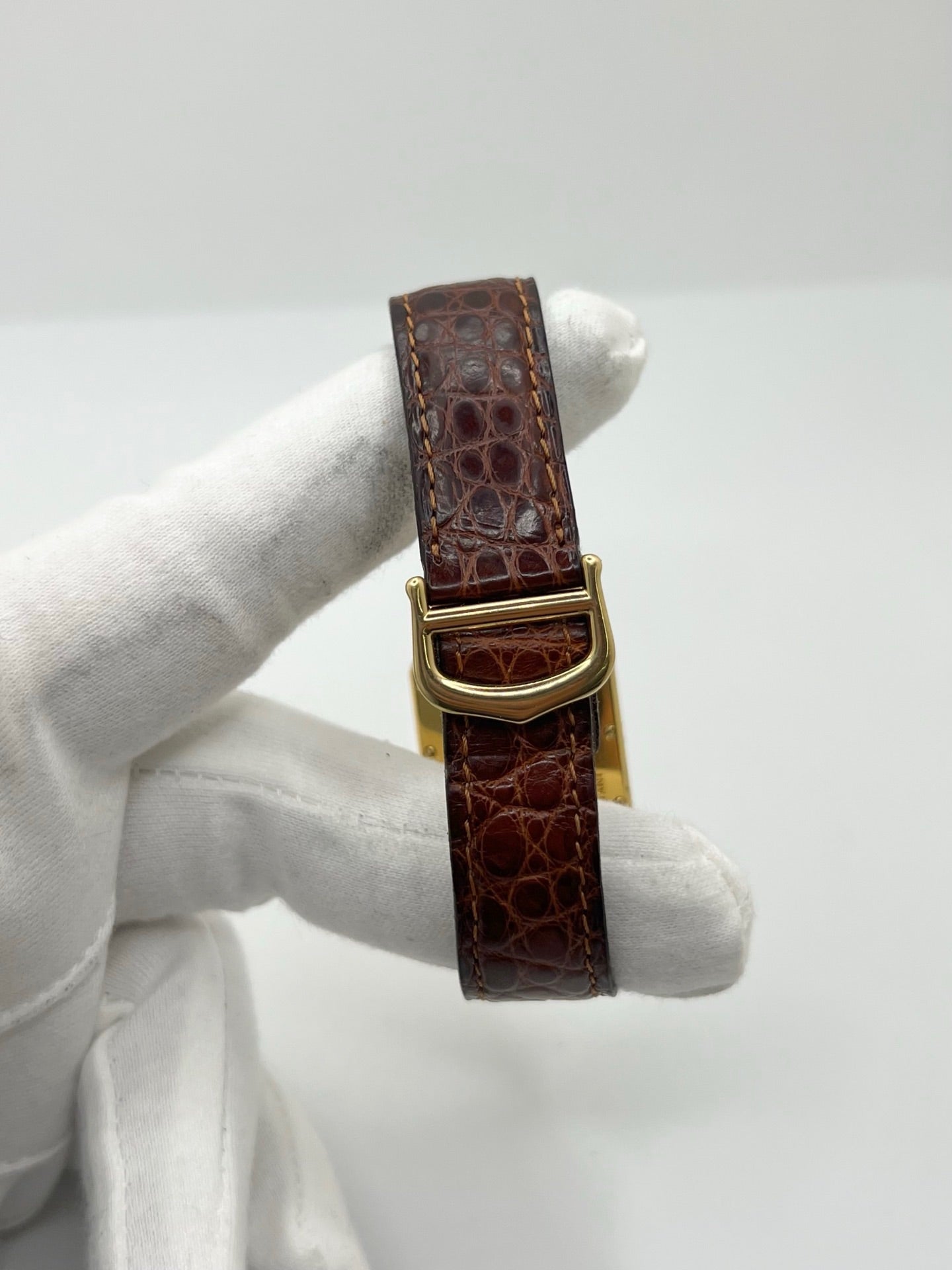 Montre Cartier Tank Must grand modèle en argent avec cadran blanc à chiffres romains, mouvement quartz et fonction date. Boîtier rectangulaire 25 x 33 mm avec verre minéral, bracelet en cuir brun et boucle ardillon en acier. Modèle iconique au design élégant et intemporel, idéal pour homme ou unisexe. Montre d’occasion en bon état, révisée, avec coffret d’origine.