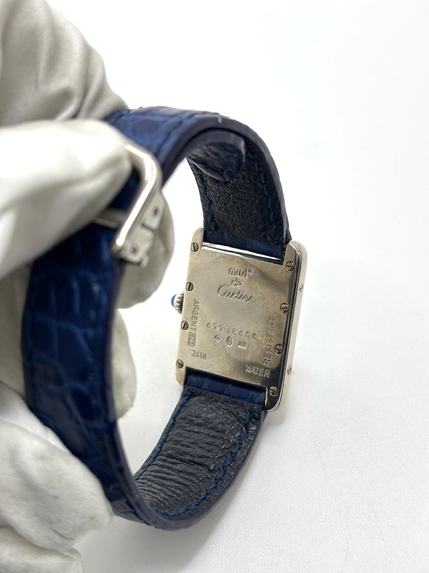 Montre Cartier Tank Must référence 2416 en argent avec cadran blanc à chiffres arabes et mouvement quartz. Ce modèle iconique présente un boîtier rectangulaire de 22 x 30 mm, une lunette en argent et un bracelet en cuir bleu avec boucle ardillon en acier. Cartier Tank Must d'occasion en très bon état, avec de légères traces d'usure. Montre homme ou unisexe élégante et intemporelle, idéale pour les amateurs d'horlogerie et de montres de luxe vintage.
