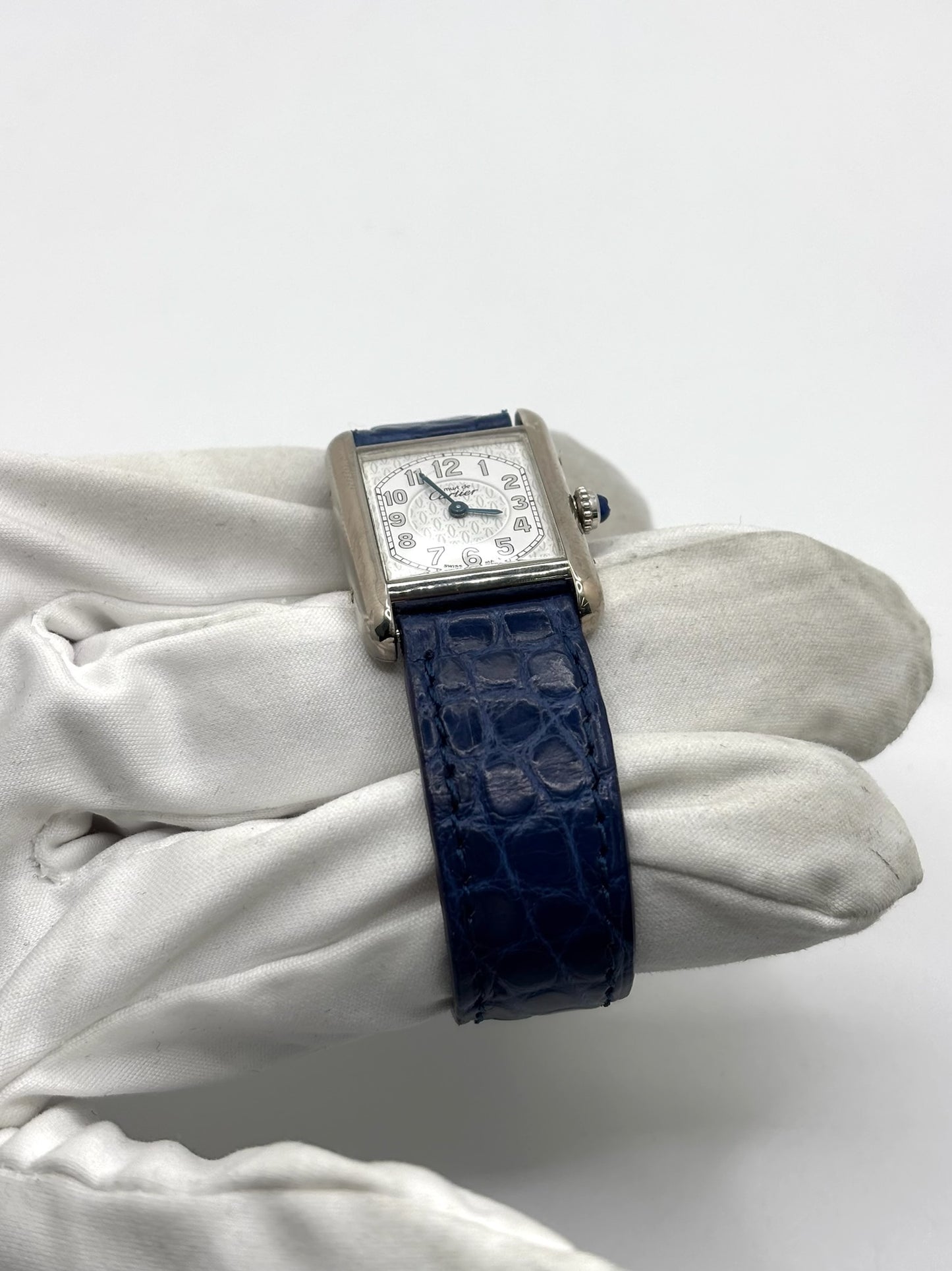 Montre Cartier Tank Must référence 2416 en argent avec cadran blanc à chiffres arabes et mouvement quartz. Ce modèle iconique présente un boîtier rectangulaire de 22 x 30 mm, une lunette en argent et un bracelet en cuir bleu avec boucle ardillon en acier. Cartier Tank Must d'occasion en très bon état, avec de légères traces d'usure. Montre homme ou unisexe élégante et intemporelle, idéale pour les amateurs d'horlogerie et de montres de luxe vintage.
