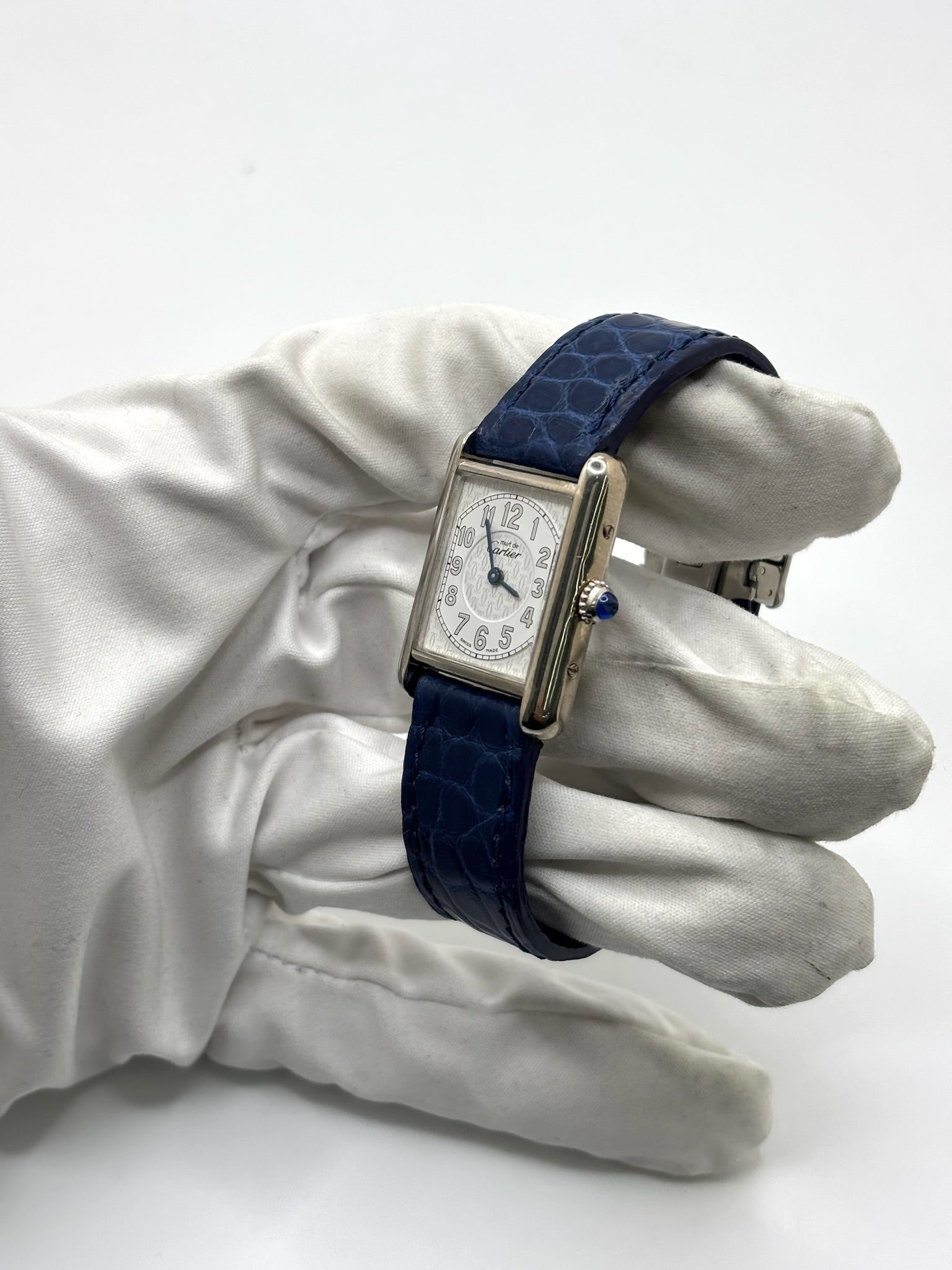 Montre Cartier Tank Must référence 2416 en argent avec cadran blanc à chiffres arabes et mouvement quartz. Ce modèle iconique présente un boîtier rectangulaire de 22 x 30 mm, une lunette en argent et un bracelet en cuir bleu avec boucle ardillon en acier. Cartier Tank Must d'occasion en très bon état, avec de légères traces d'usure. Montre homme ou unisexe élégante et intemporelle, idéale pour les amateurs d'horlogerie et de montres de luxe vintage.
